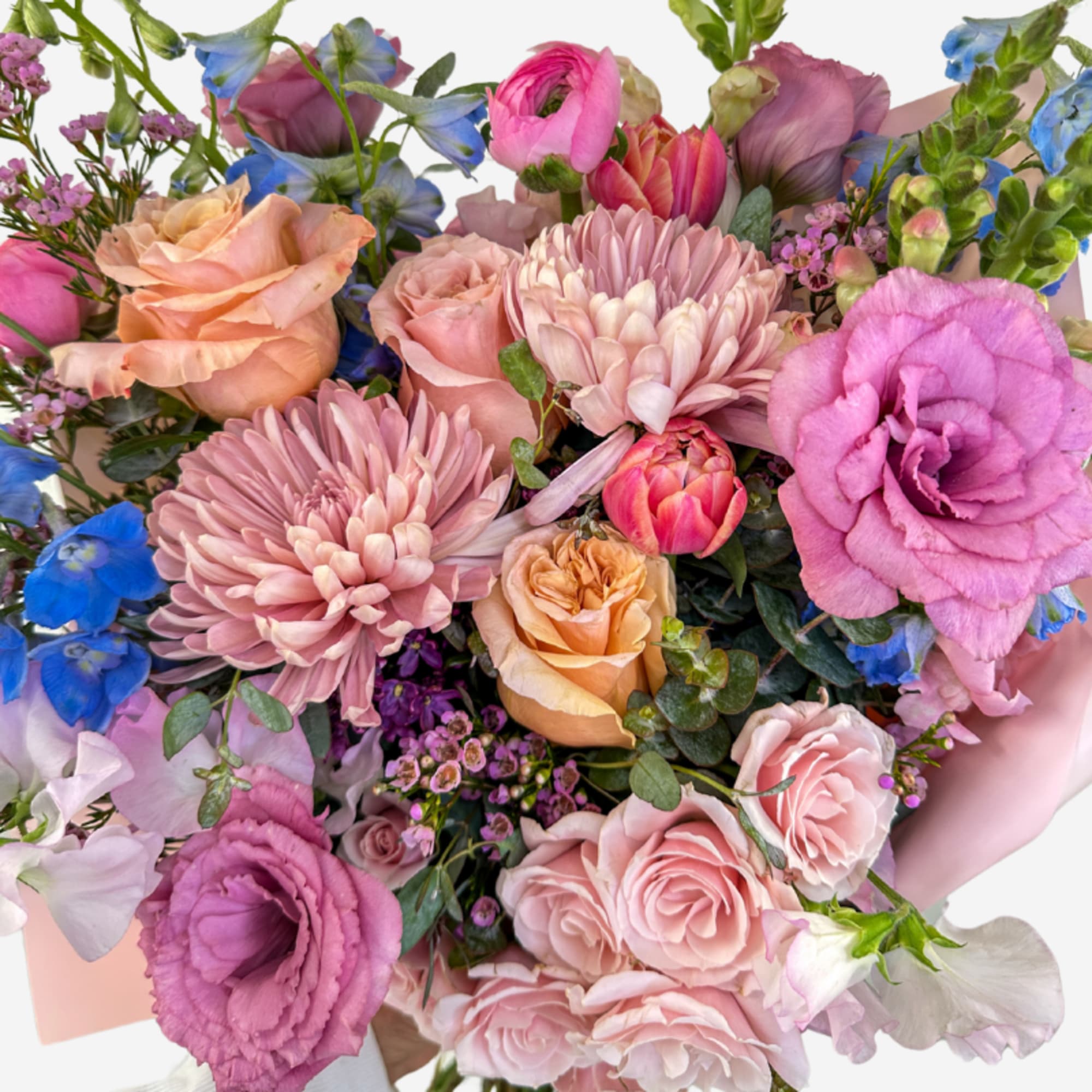 Bouquet of pink, peach, and blue flowers wrapped in pale paper