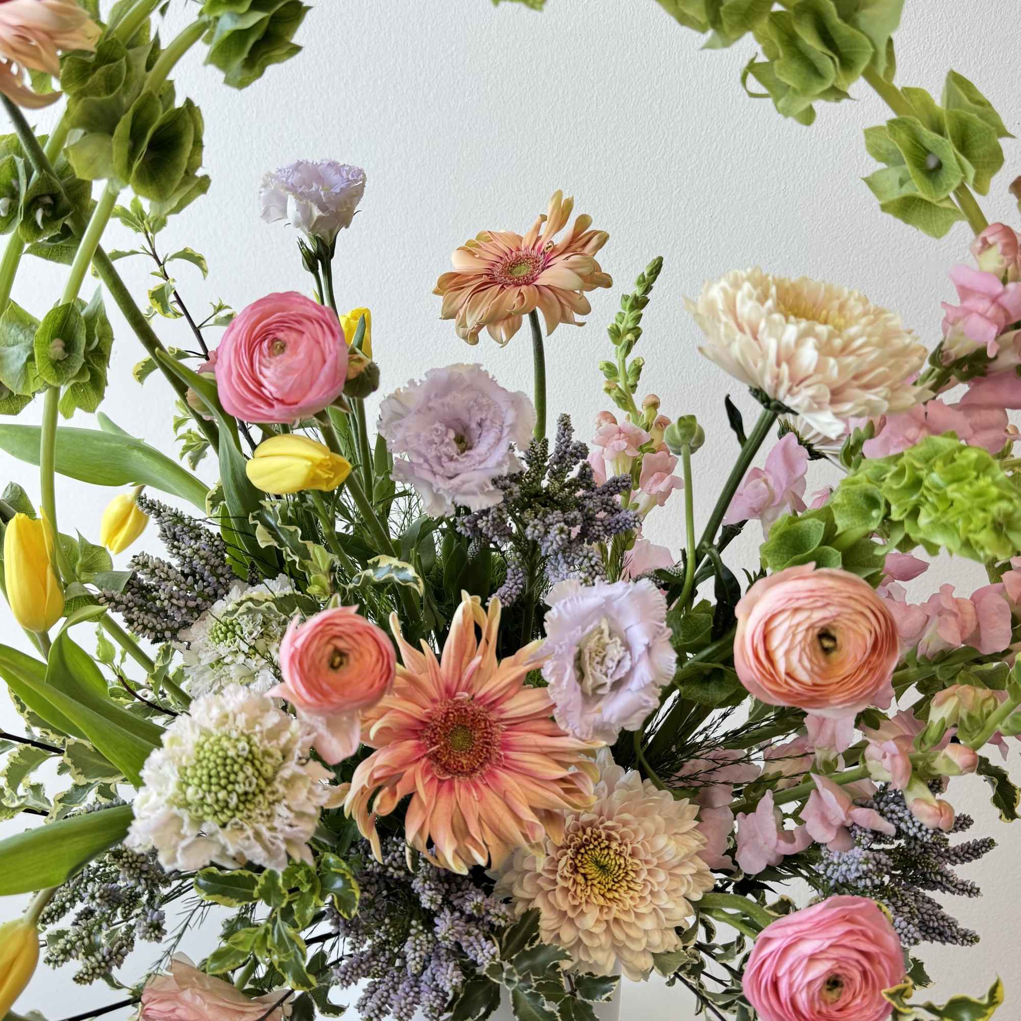 Mixed pastel flower arrangement in a white vase