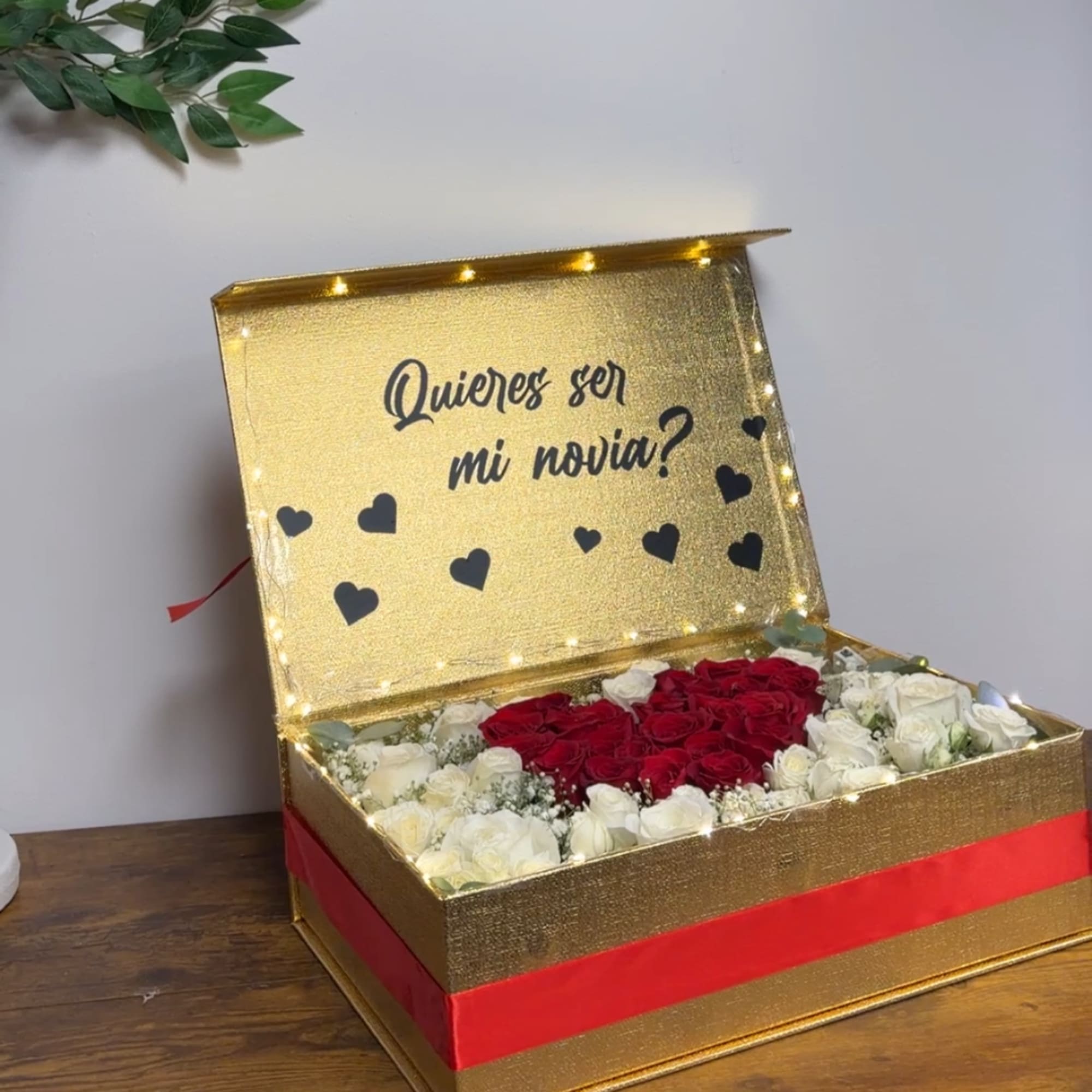 Gold gift box with red and white roses and heart decorations