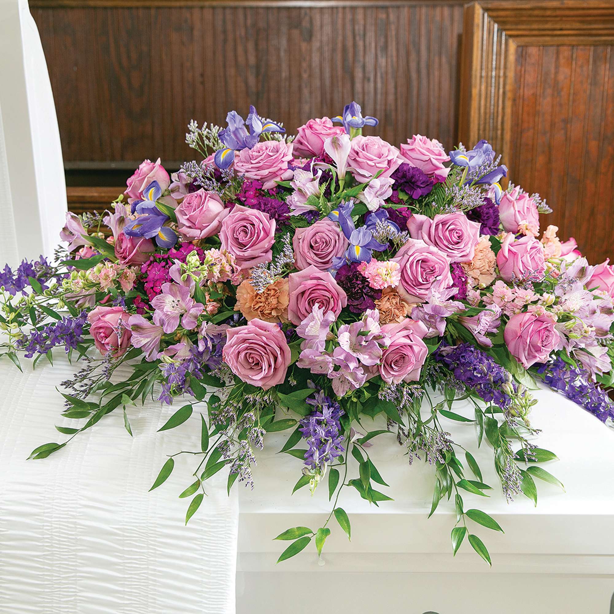 Large pink and purple floral casket spray with roses and lilies
