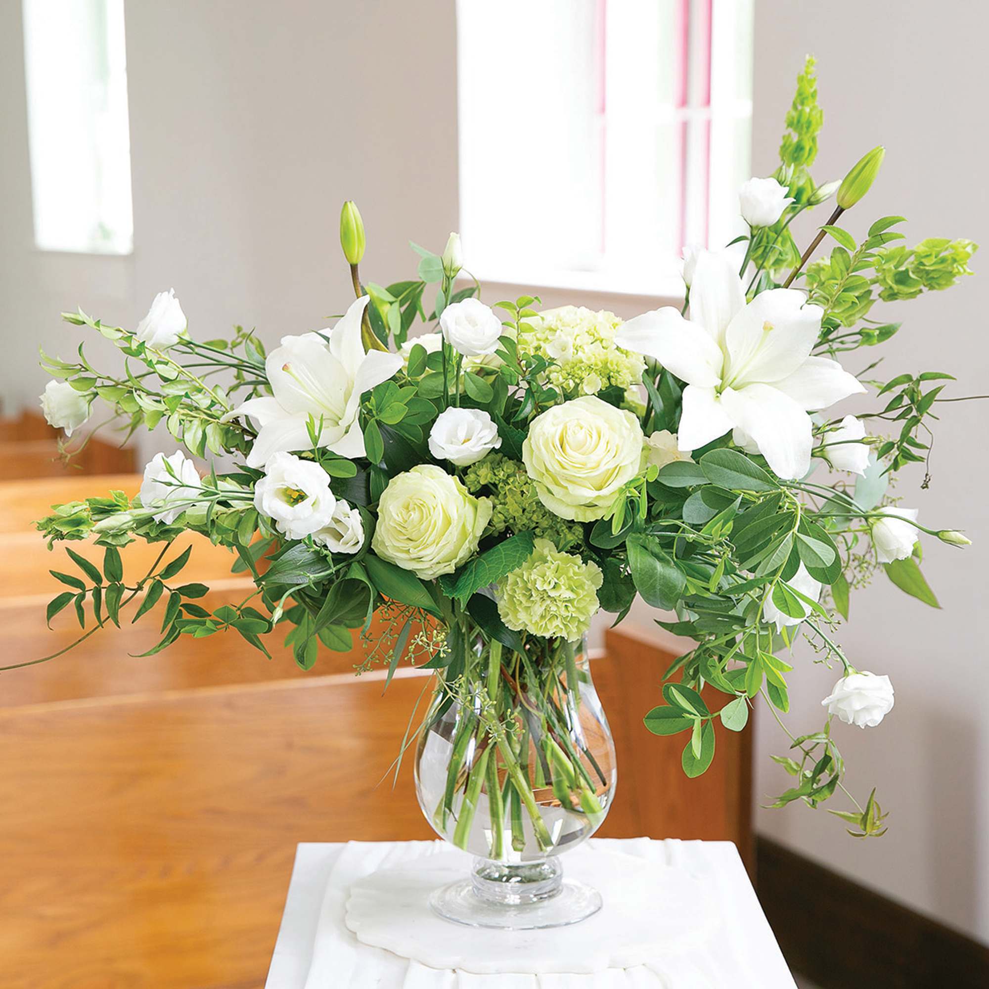 White lilies and roses in a clear glass vase