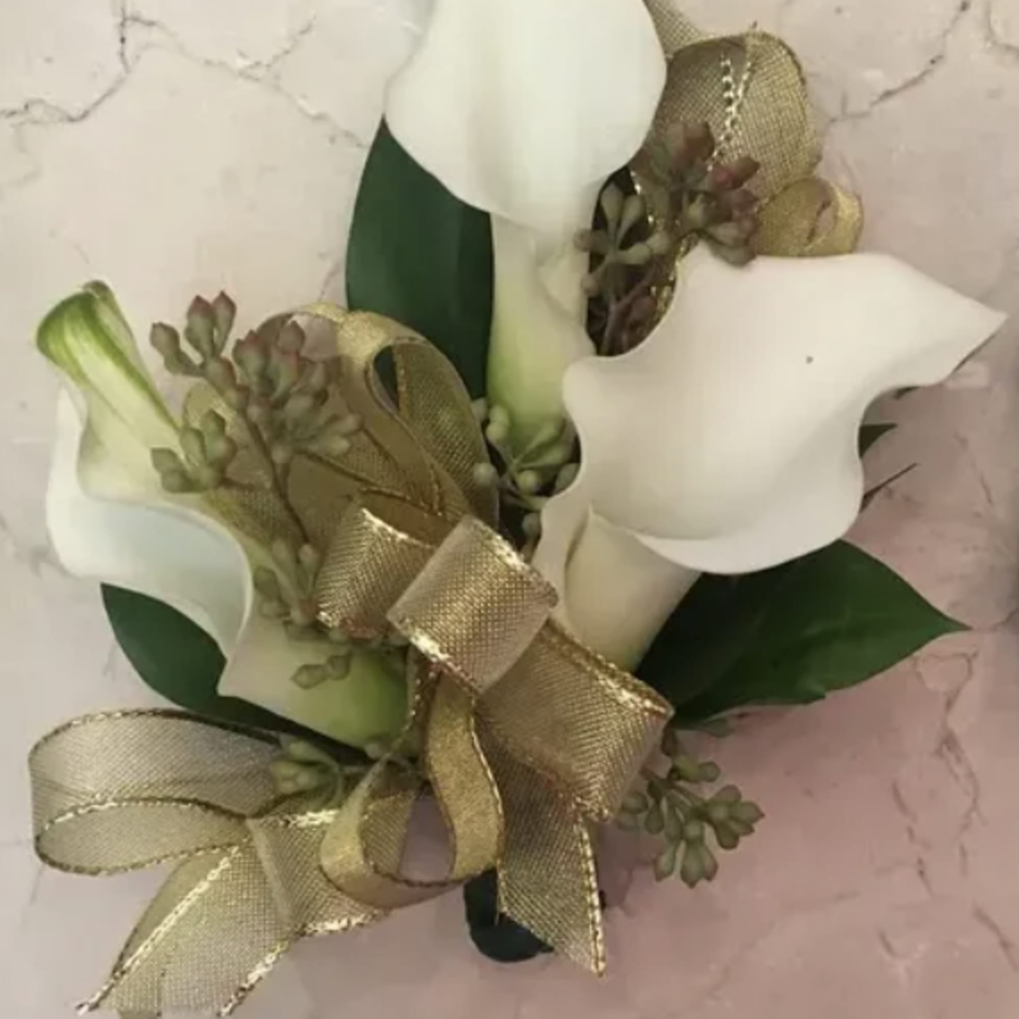 White calla lily bouquet with gold ribbon and greenery