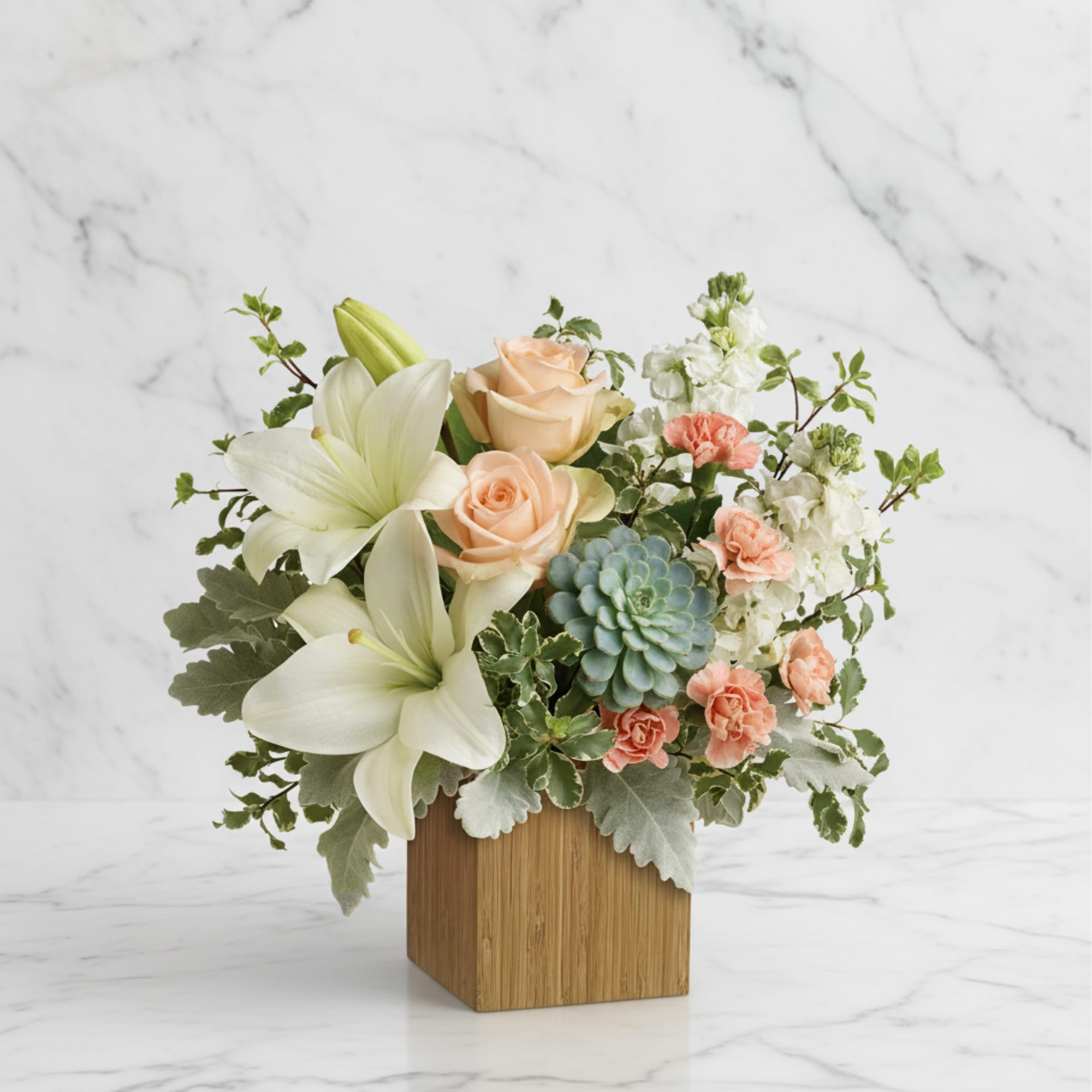 Peaceful yet energizing, this unforgettable arrangement of desert-hued blooms and succulents in
