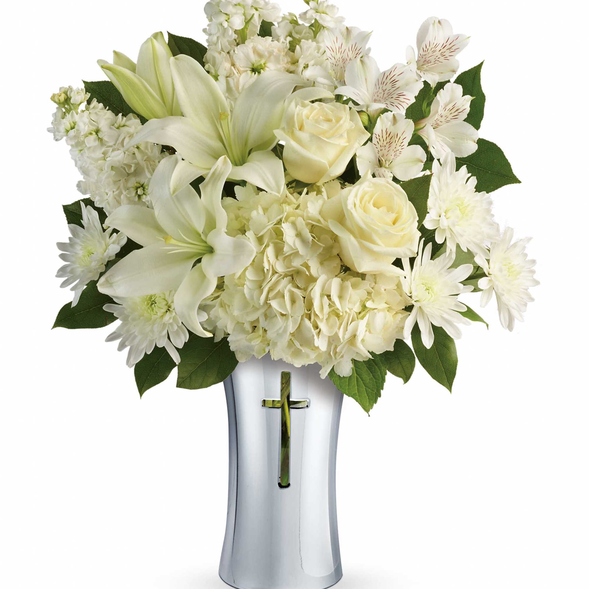 White flowers arranged in a silver vase with a cross