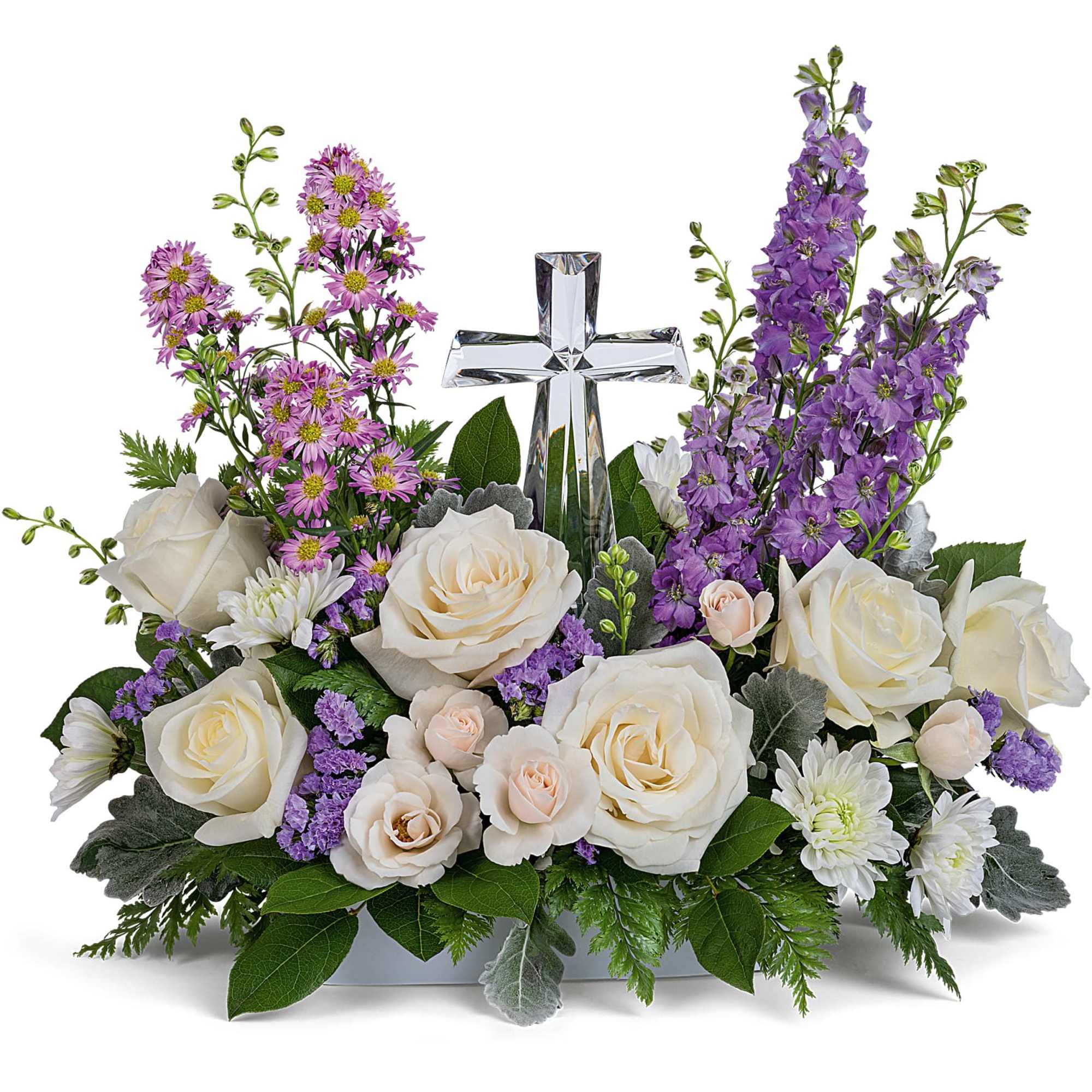 White roses and purple flowers arranged around a clear glass cross