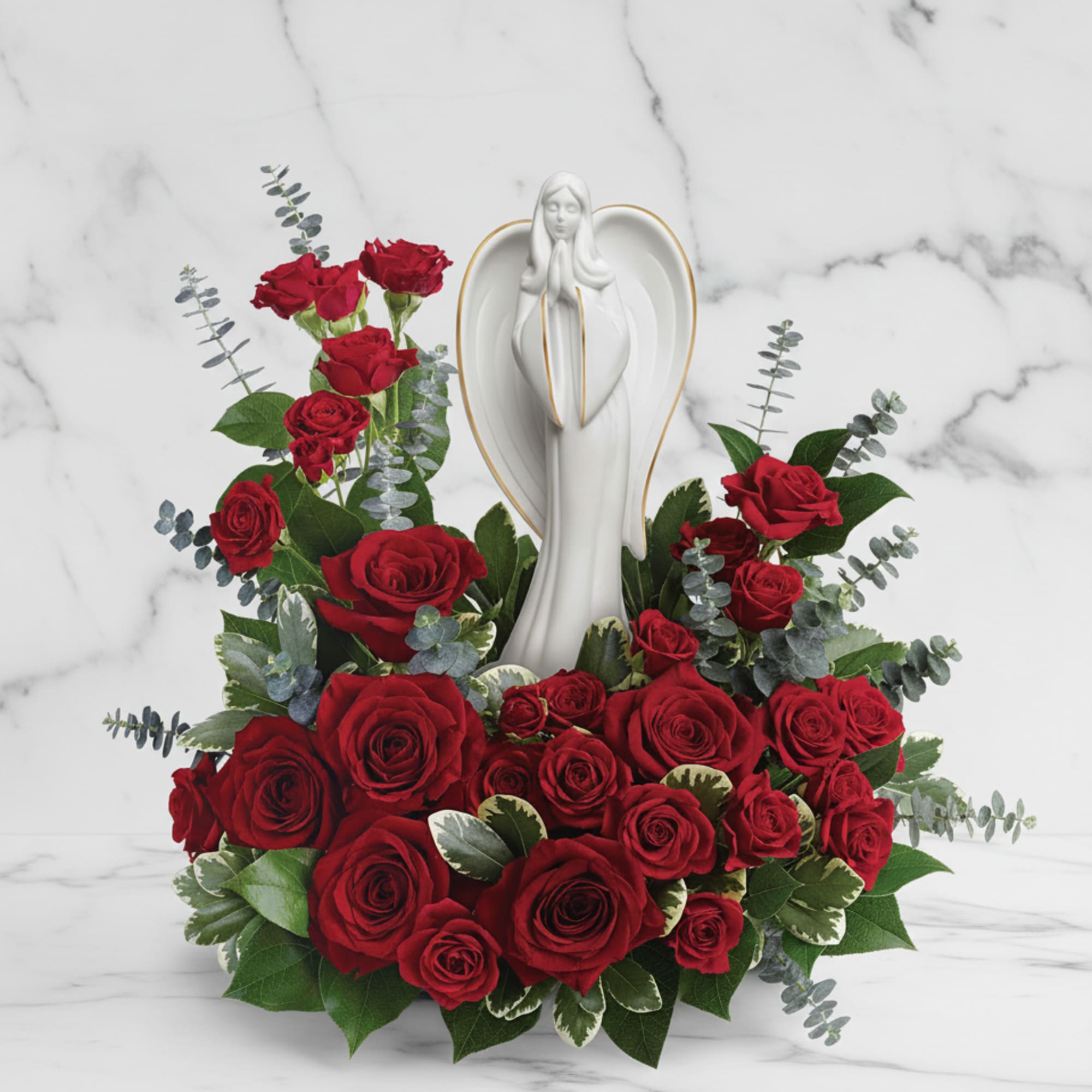 This peaceful porcelain angel sculpture, surrounded by radiant red roses and delicate