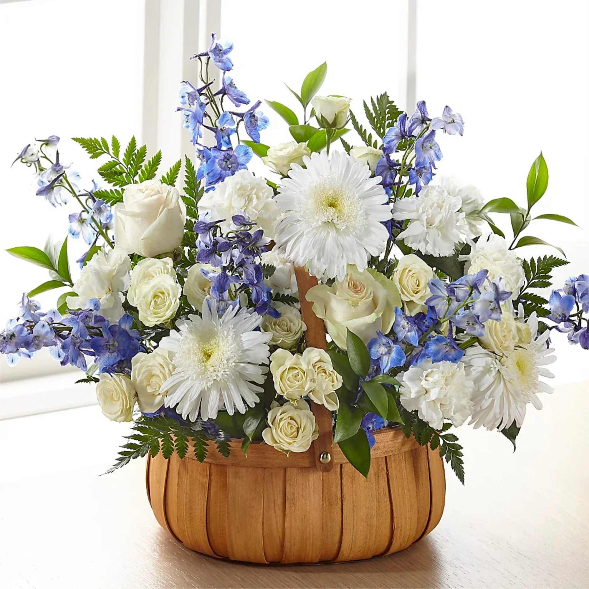 White and blue floral arrangement in a wooden basket