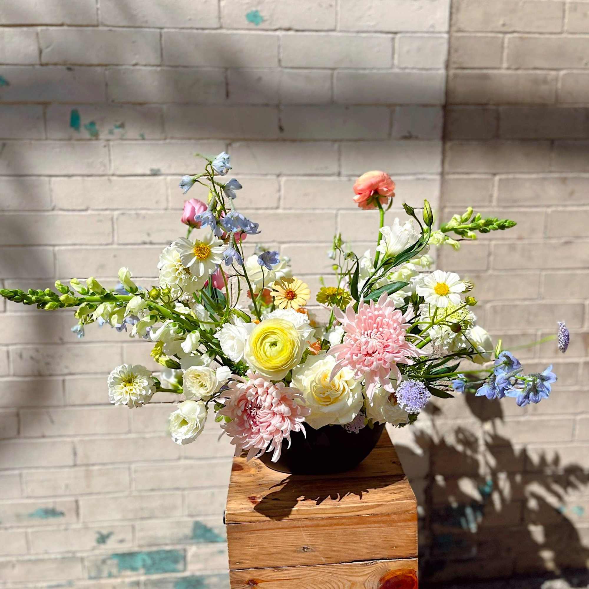 An airy, garden-inspired floral arrangement featuring blush chrysanthemums, creamy roses, ranunculus, and