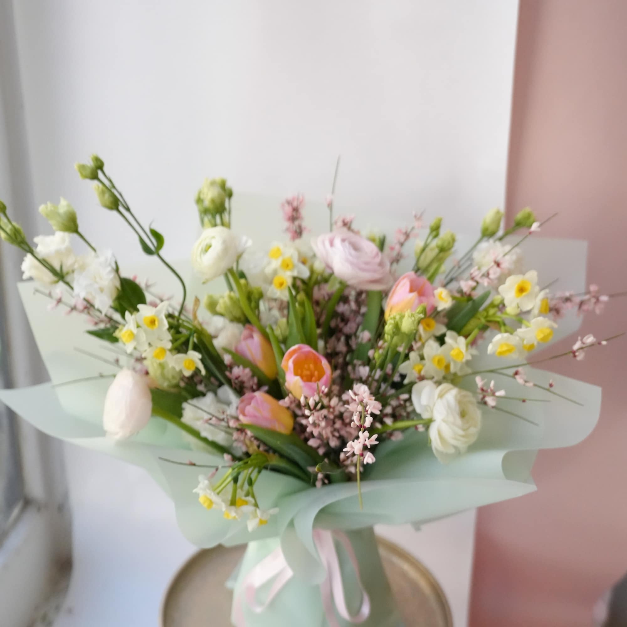 Pastel bouquet of mixed flowers wrapped in mint paper