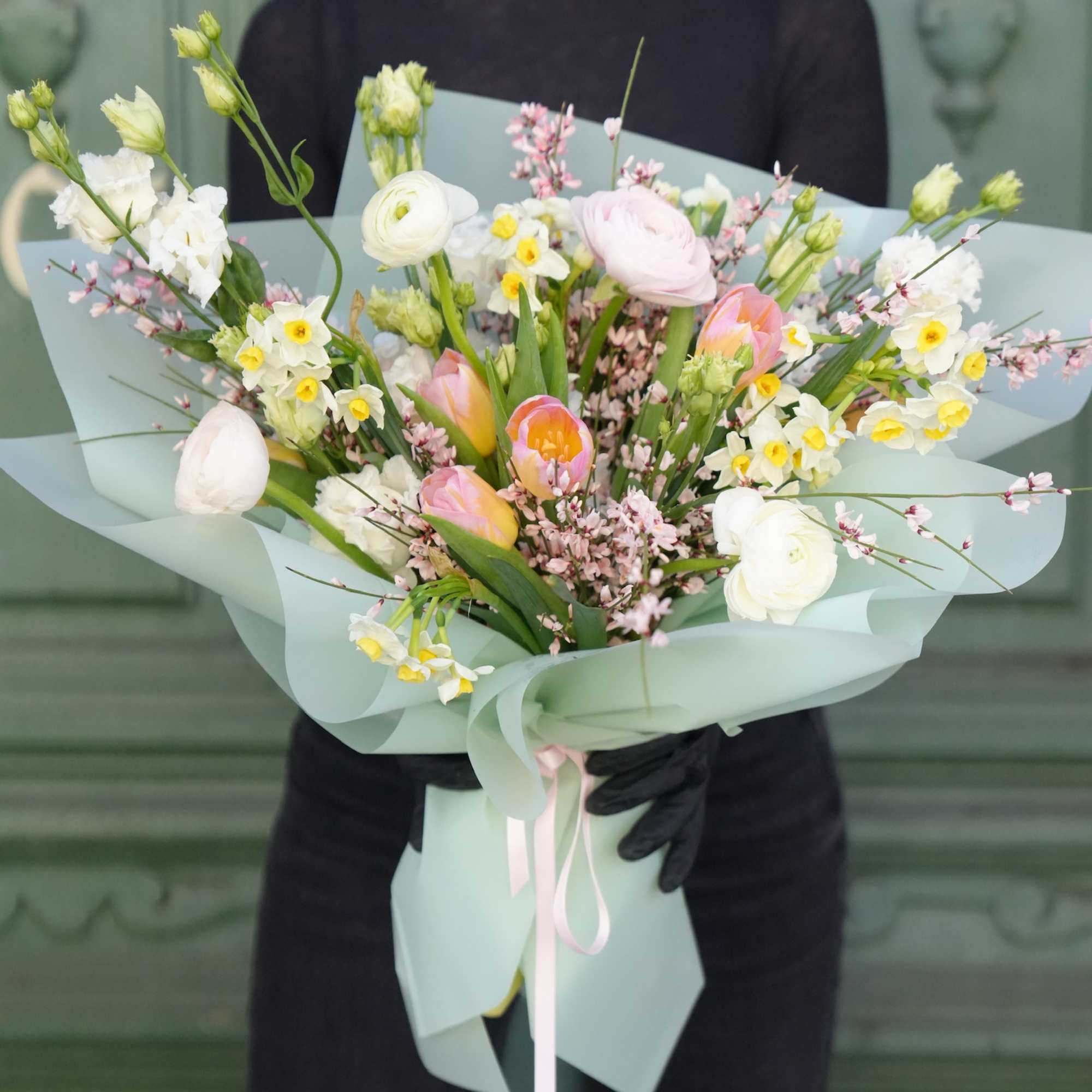 Pastel bouquet with pink and white flowers wrapped in pale blue paper