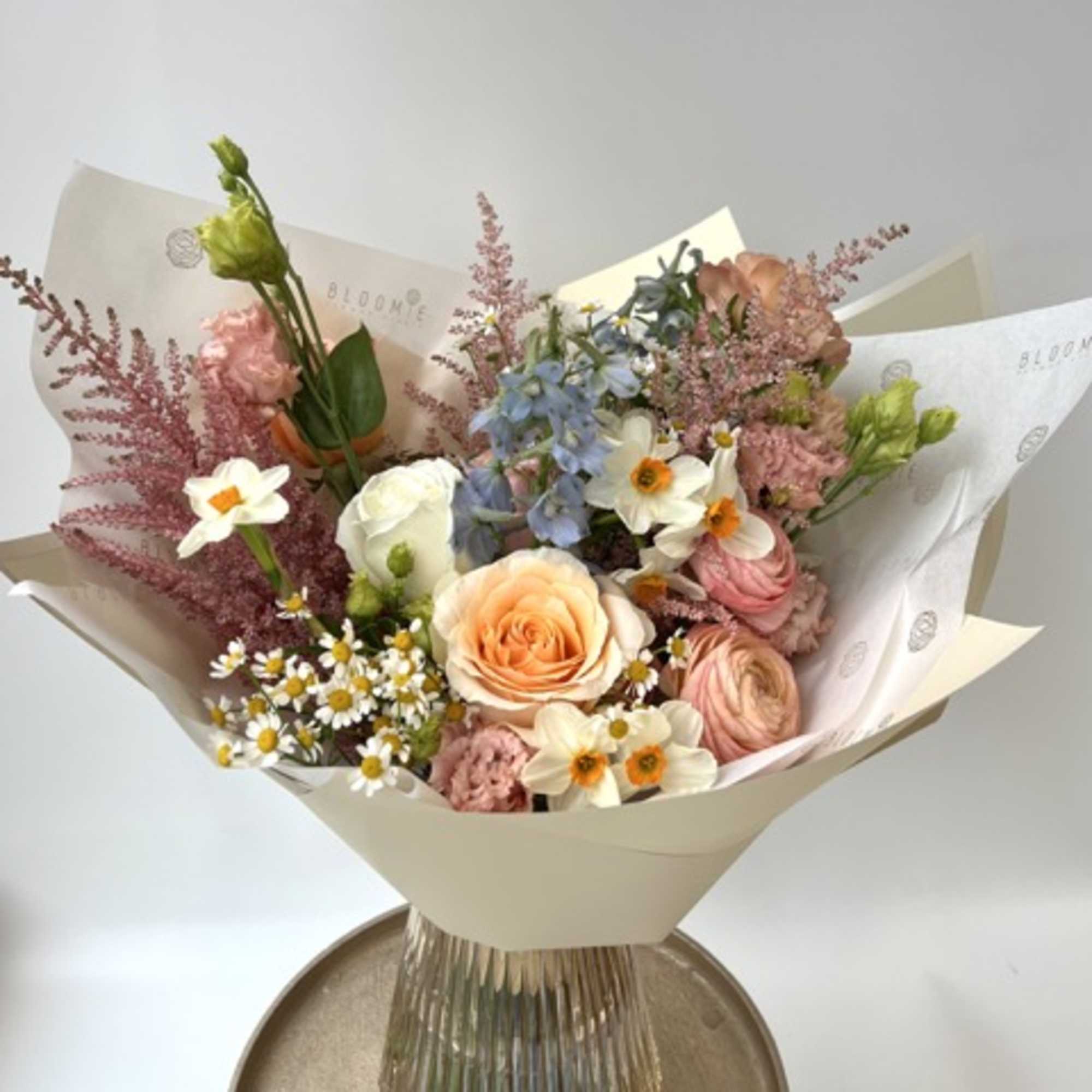 Mixed pastel bouquet in a clear ribbed vase