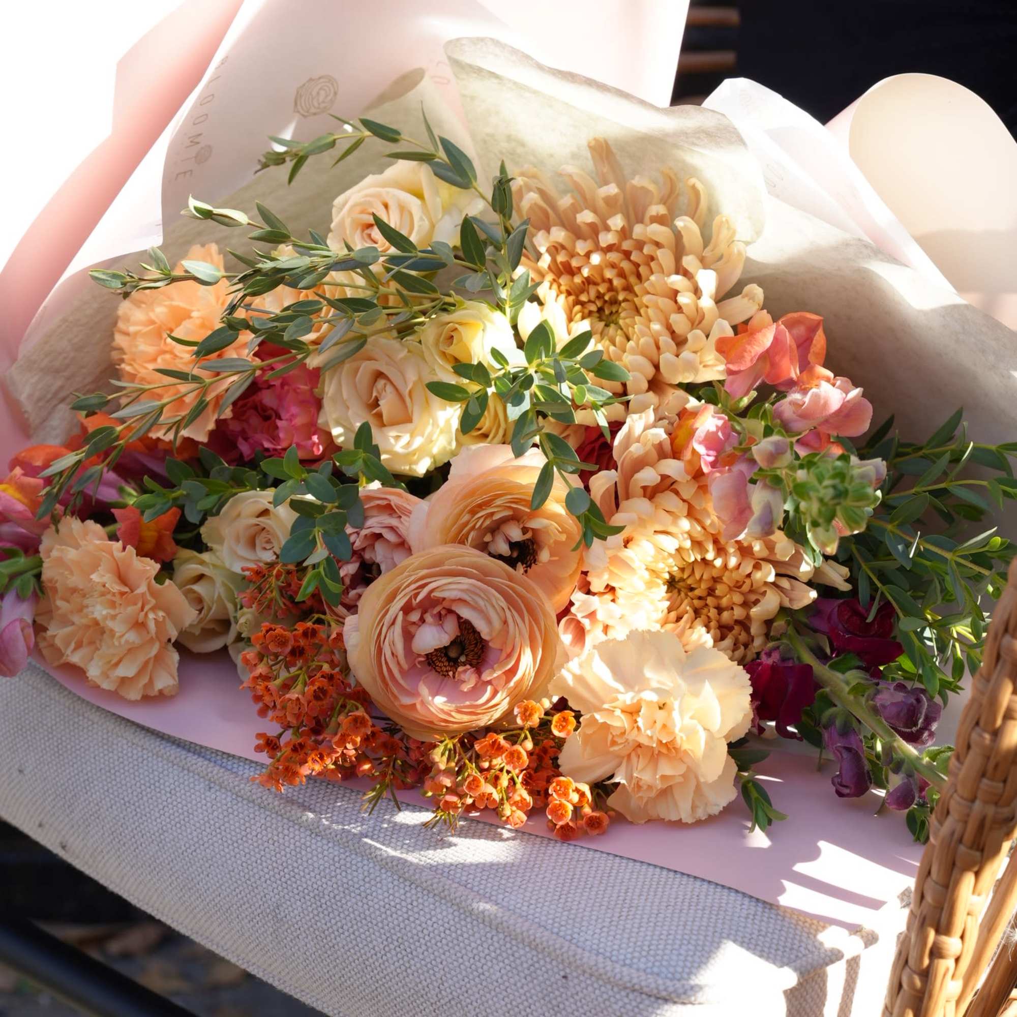 Peach and cream bouquet with roses, ranunculus, carnations, and chrysanthemums