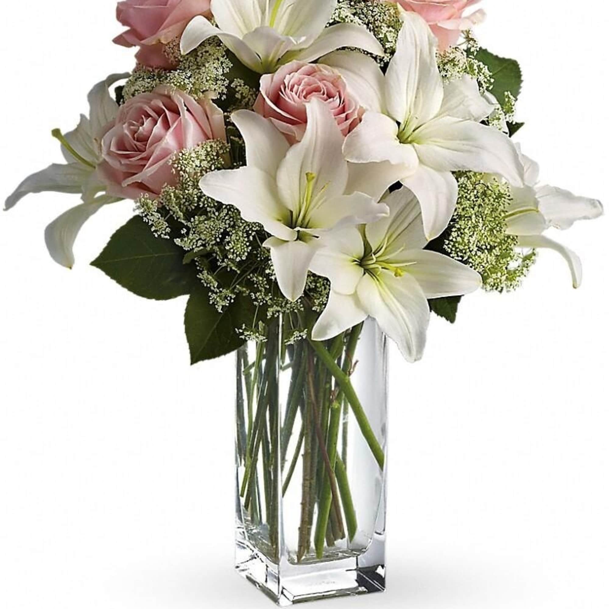 Tall clear vase with white lilies and light pink roses in a mixed arrangement