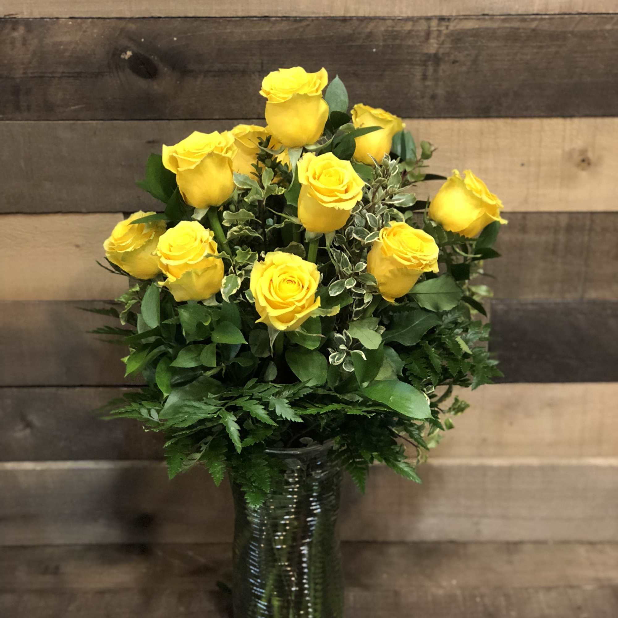 Yellow roses arranged in a clear glass vase