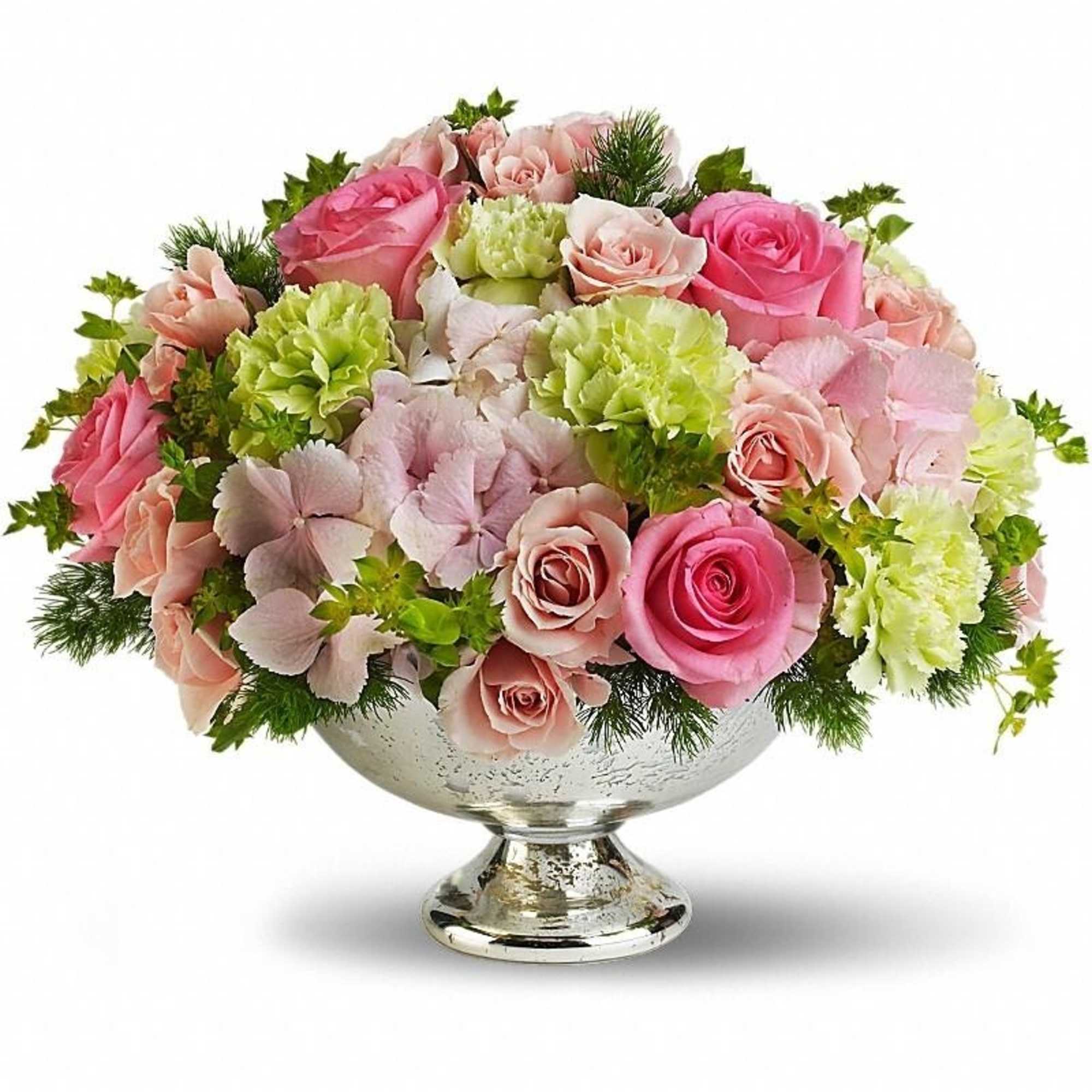 Low arrangement of pink roses, green carnations, and pale hydrangeas in a silver pedestal bowl