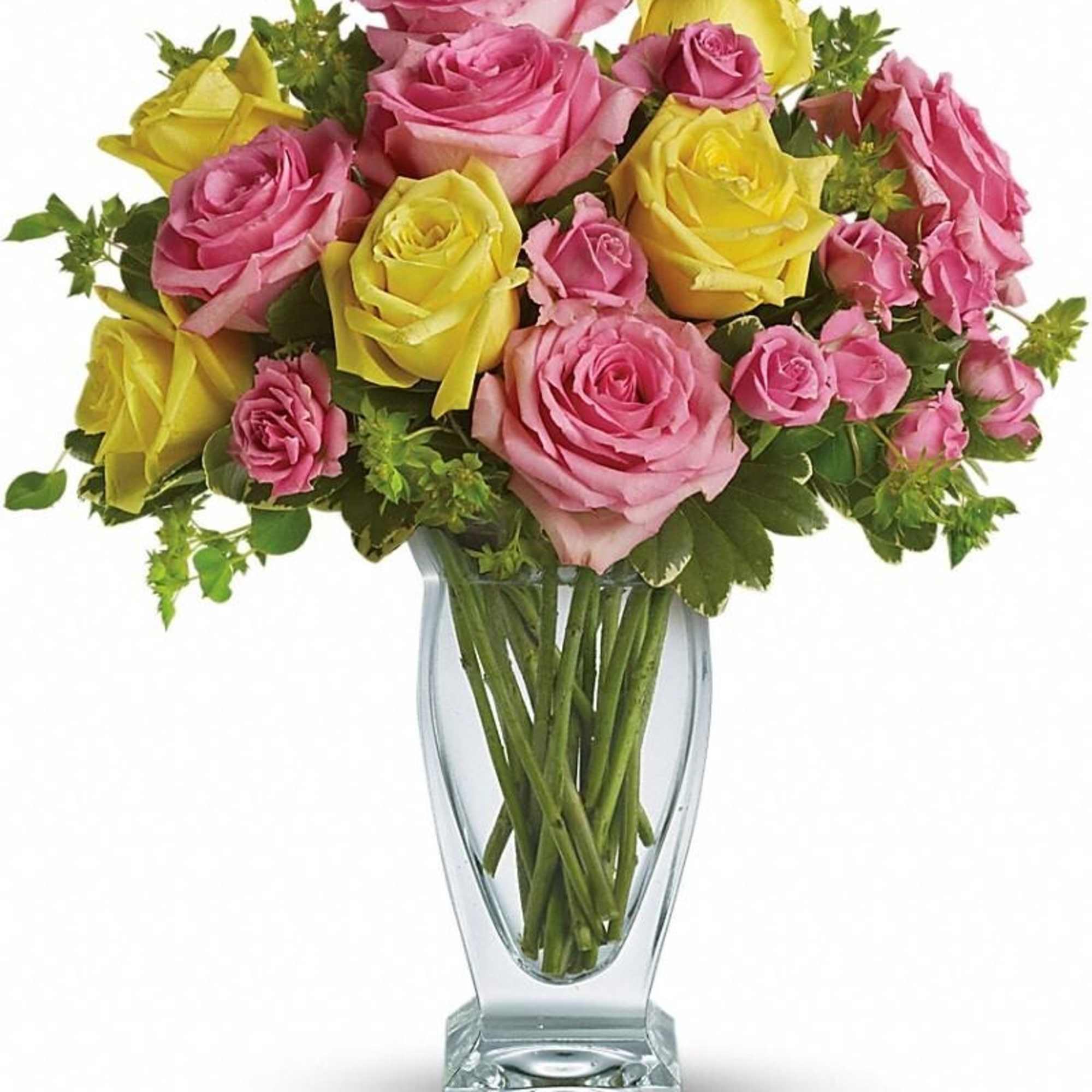 Tall clear vase of pink and yellow roses arranged in a mixed bouquet