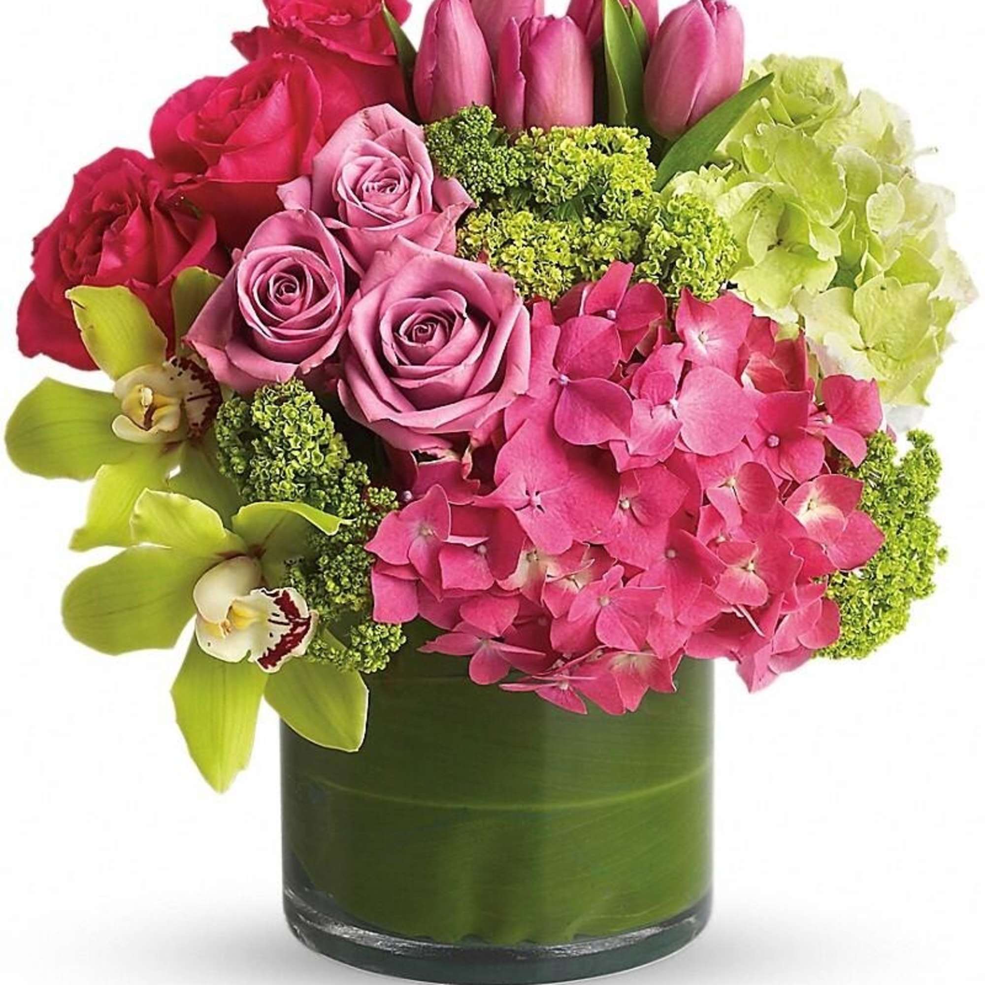 Compact arrangement of pink roses, tulips, and hydrangeas with green orchids in a glass cylinder vase