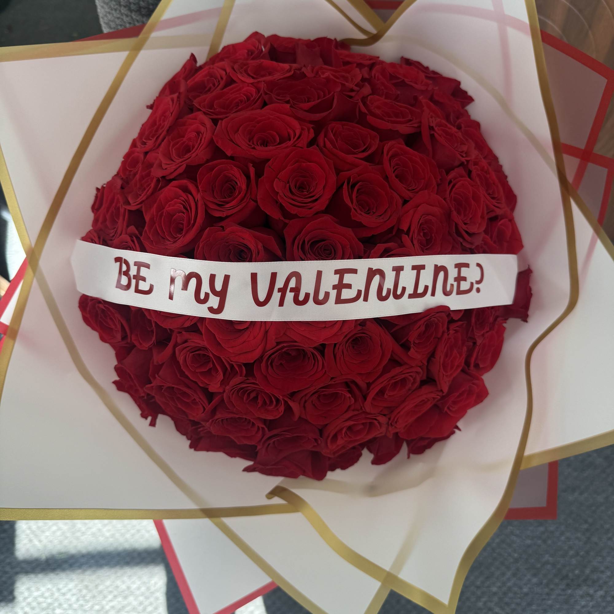 Round bouquet of red roses with a "Be my Valentine" ribbon