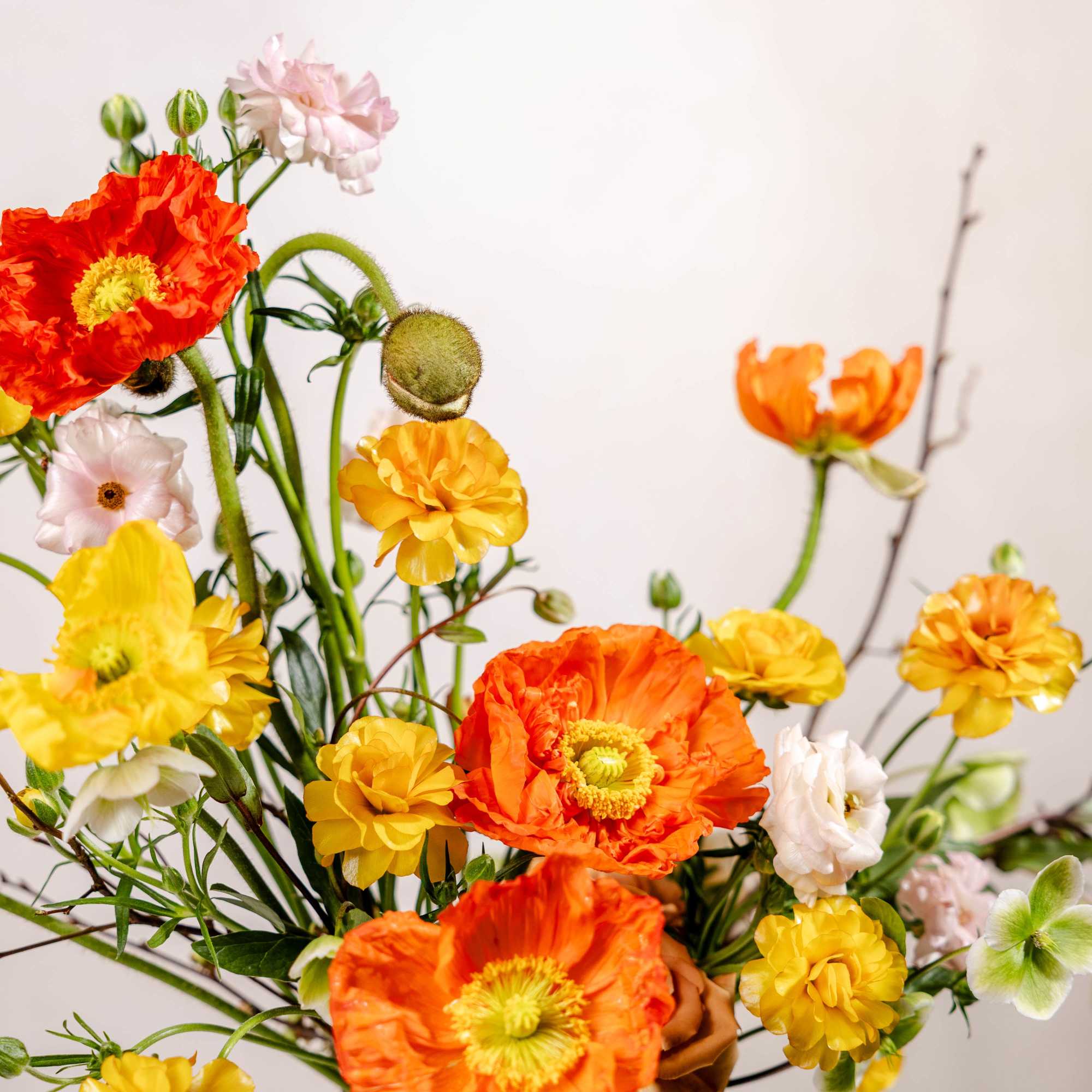 Bouquet of orange, yellow, and pale pink flowers with long stems