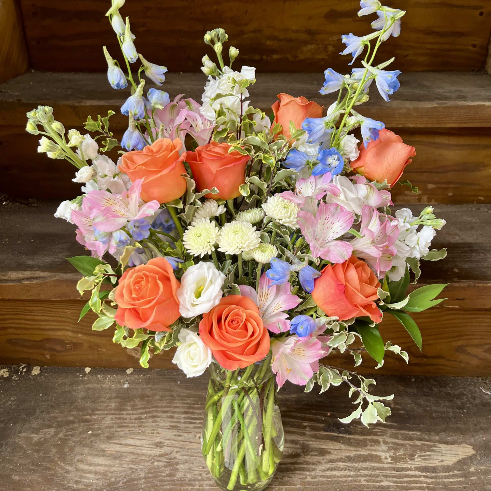 A tall elegant design of blue delphinium, light pink alstromeria, fragrant white