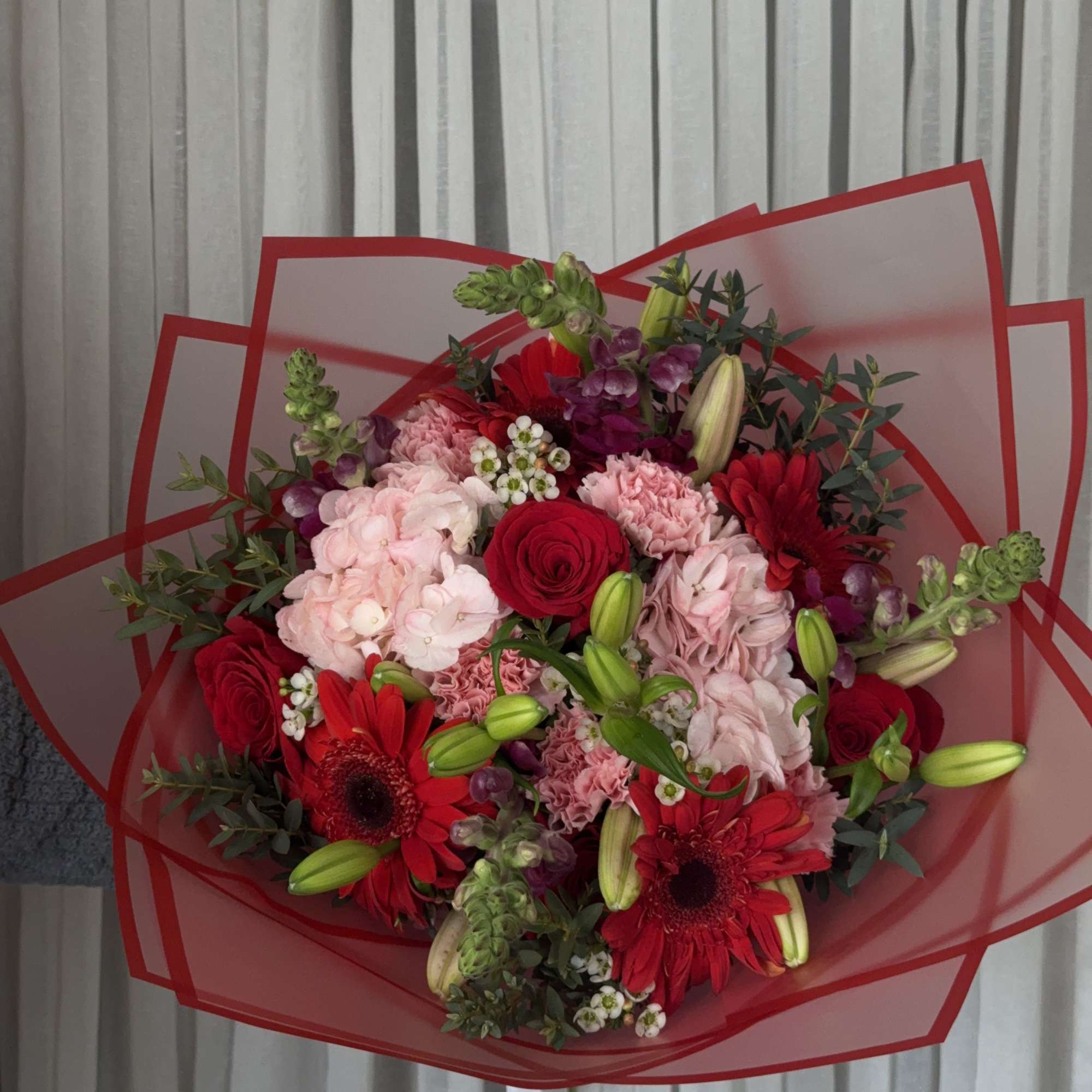 Bouquet of red and pink flowers wrapped in red paper