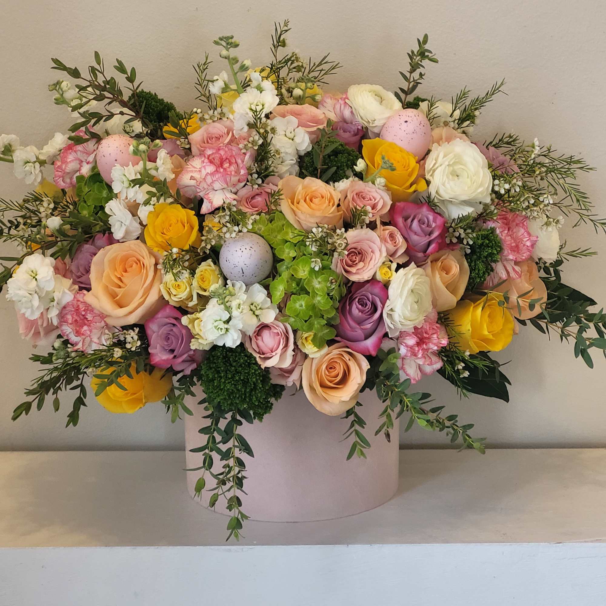 A lush, garden-style spring bouquet arranged low and full in a round