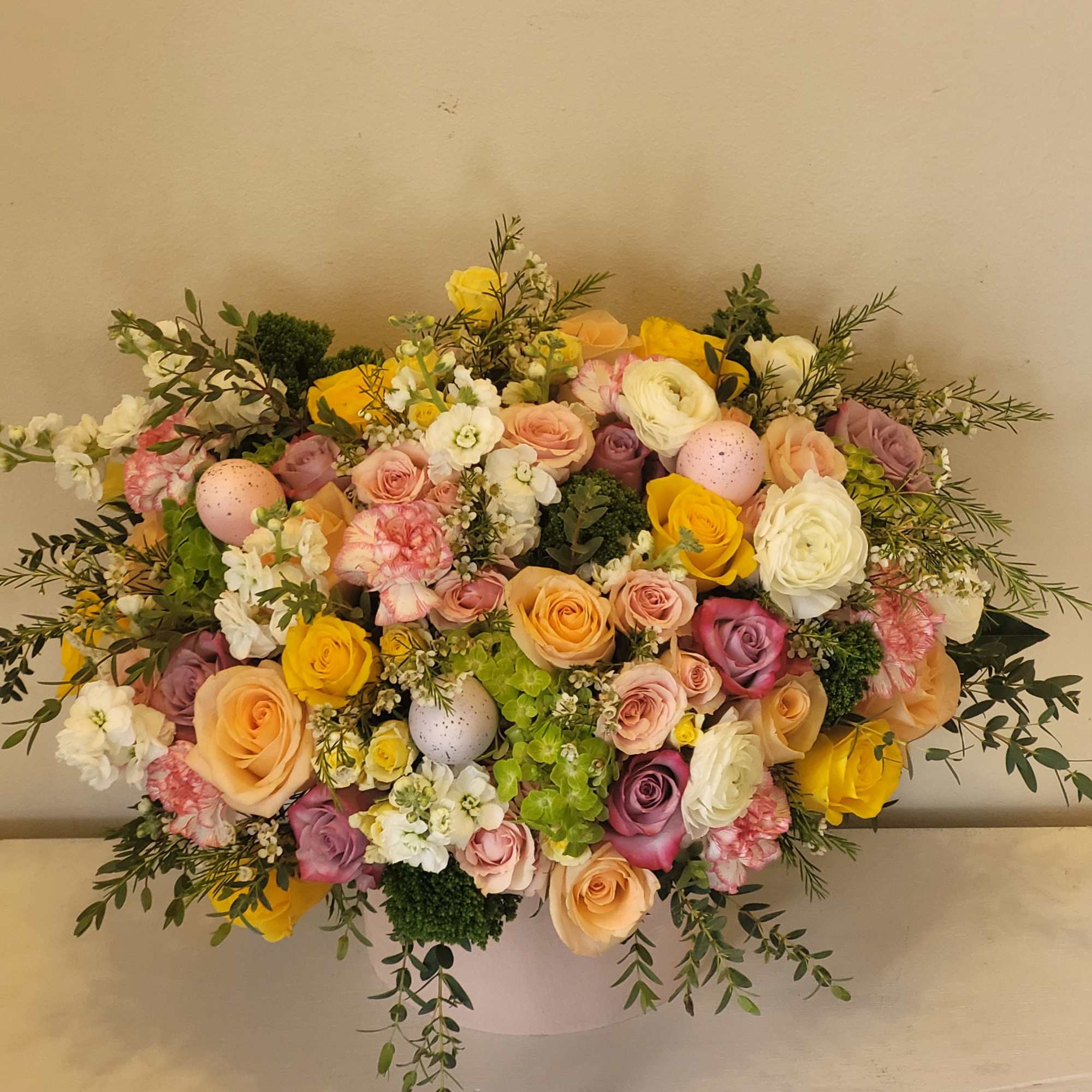 A lush, garden-style spring bouquet arranged low and full in a round