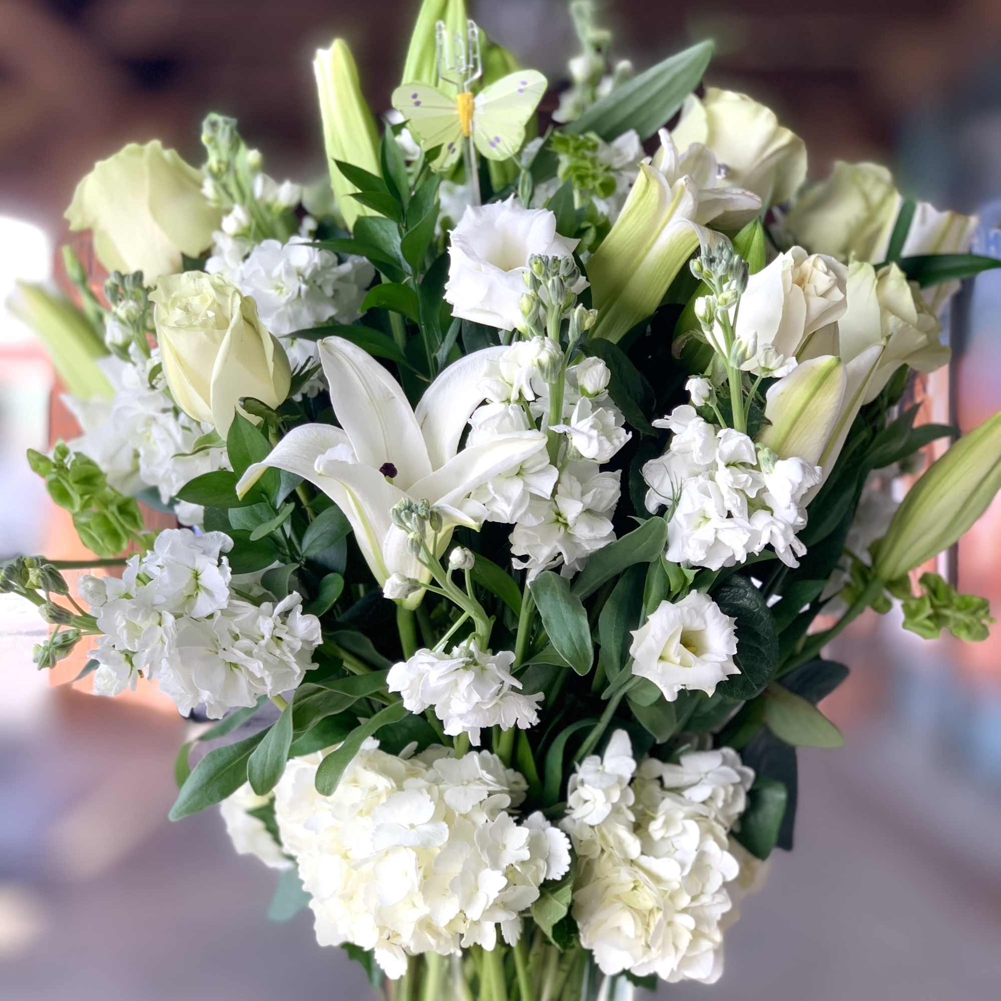White lilies and roses in a clear glass vase