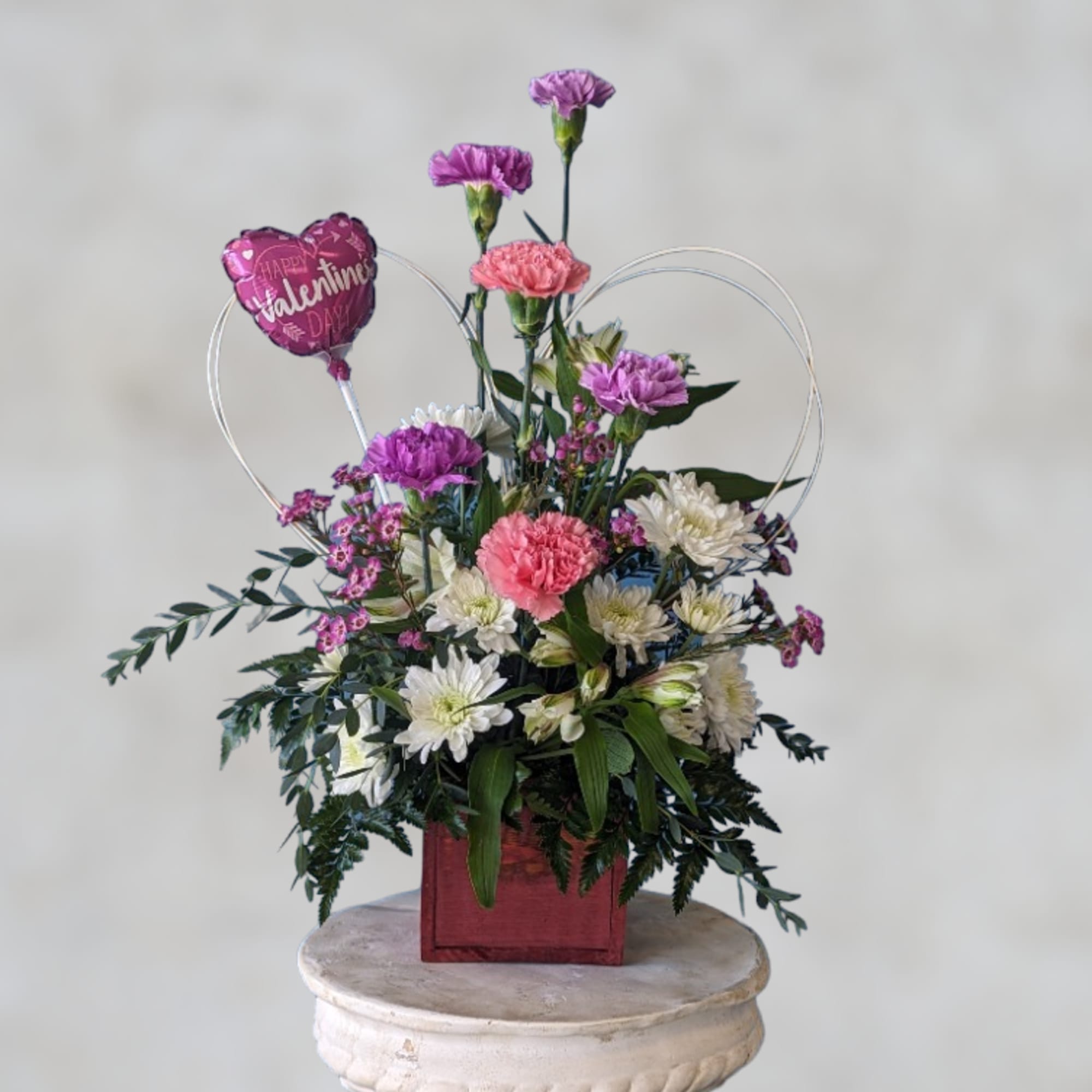 Pink and white floral arrangement with a heart-shaped Valentine balloon