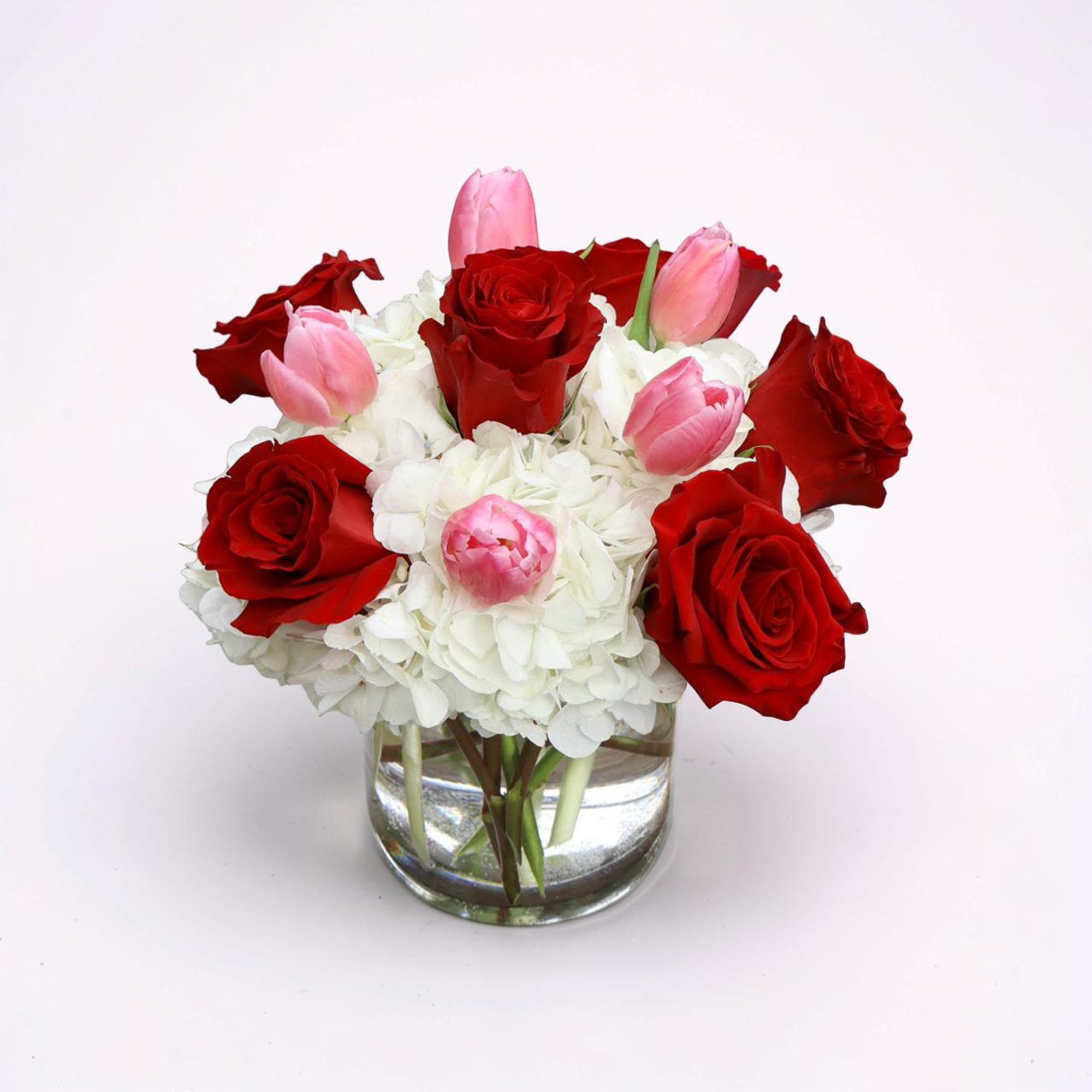 A timeless arrangement of velvety red roses and soft pink tulips nestled