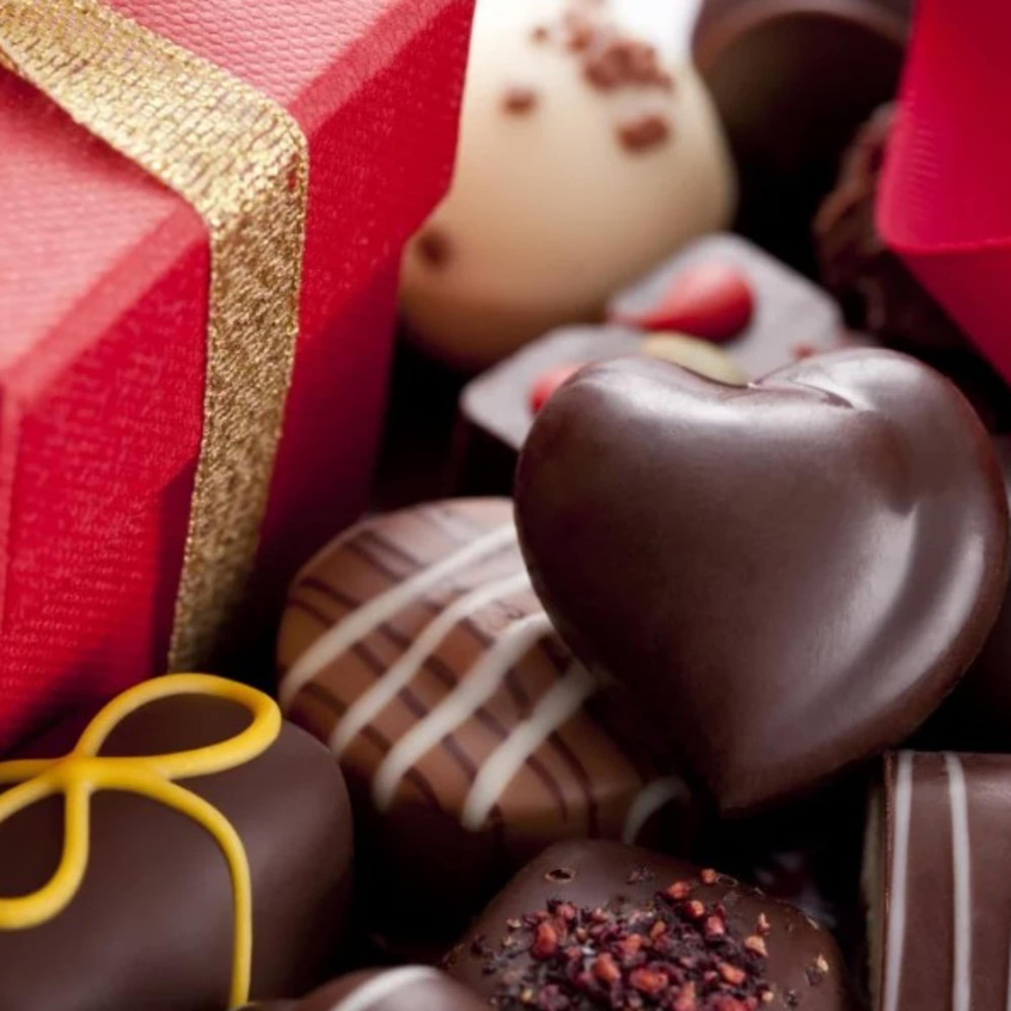 Boxed chocolates with red gift boxes and ribbon