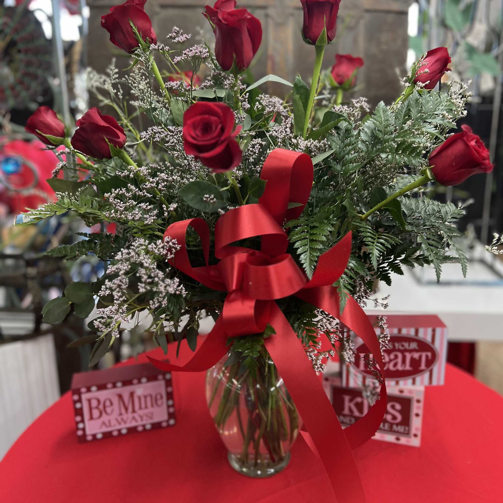 Red roses in a glass vase with a red ribbon bow