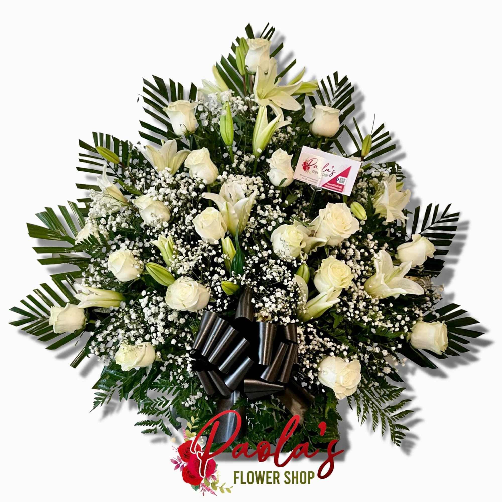 White rose and lily funeral wreath with black ribbon