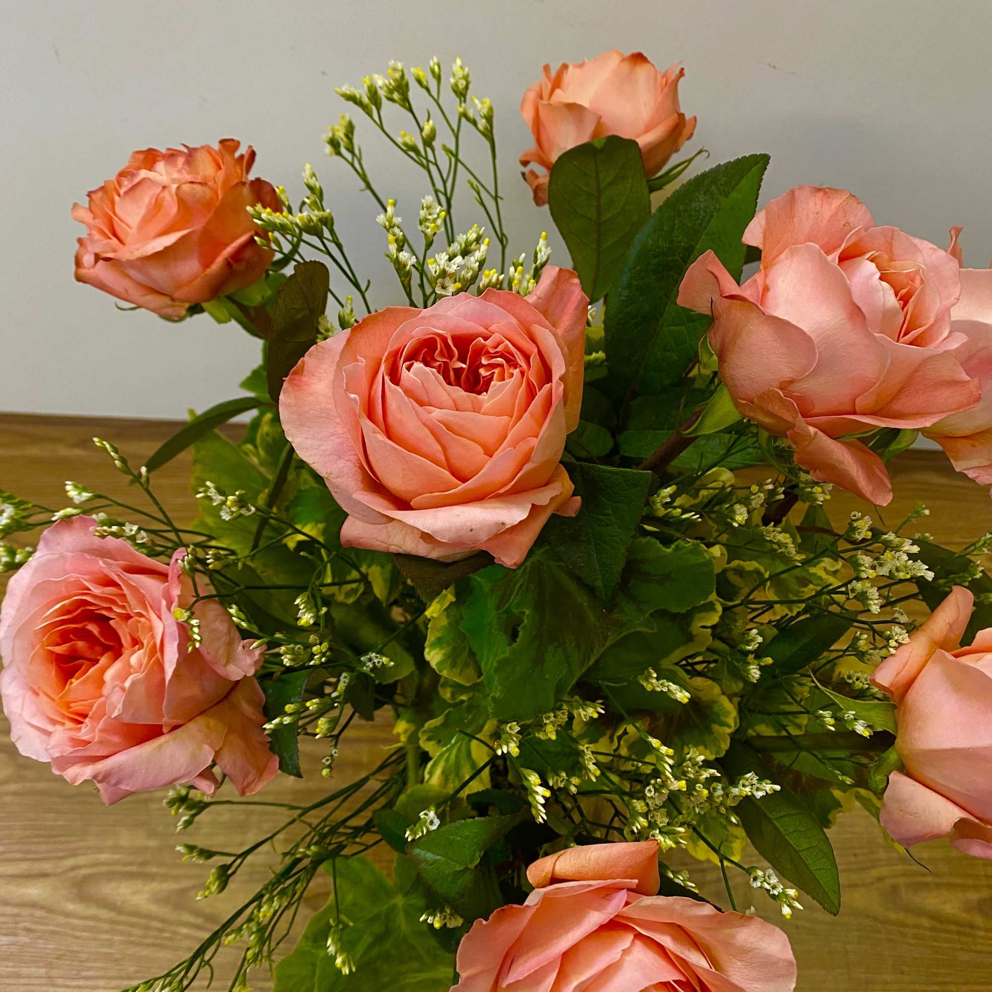 Bouquet of peach-pink roses with small white filler flowers