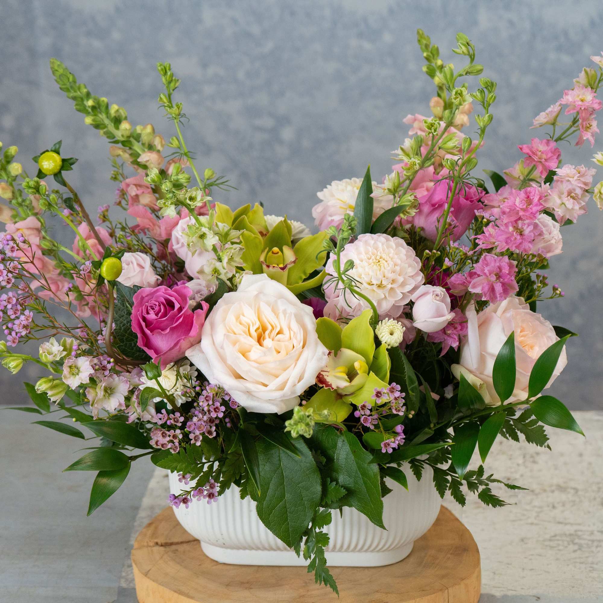 Cream and blush roses mingle with bright green orchids and tall spires