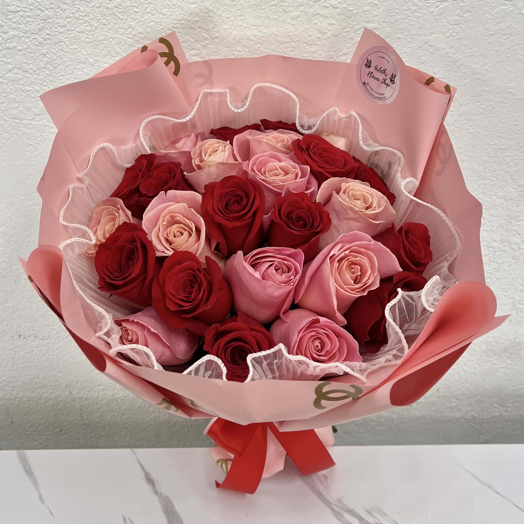 Bouquet of red and pink roses wrapped in pink paper