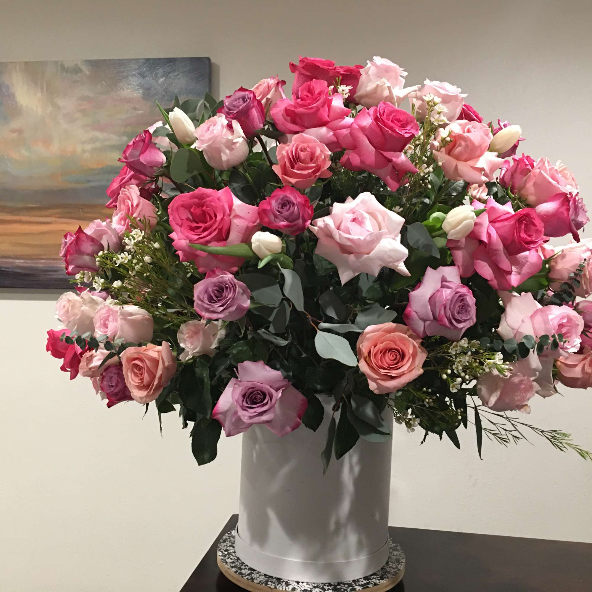 Large bouquet of pink and lavender roses in a white vase