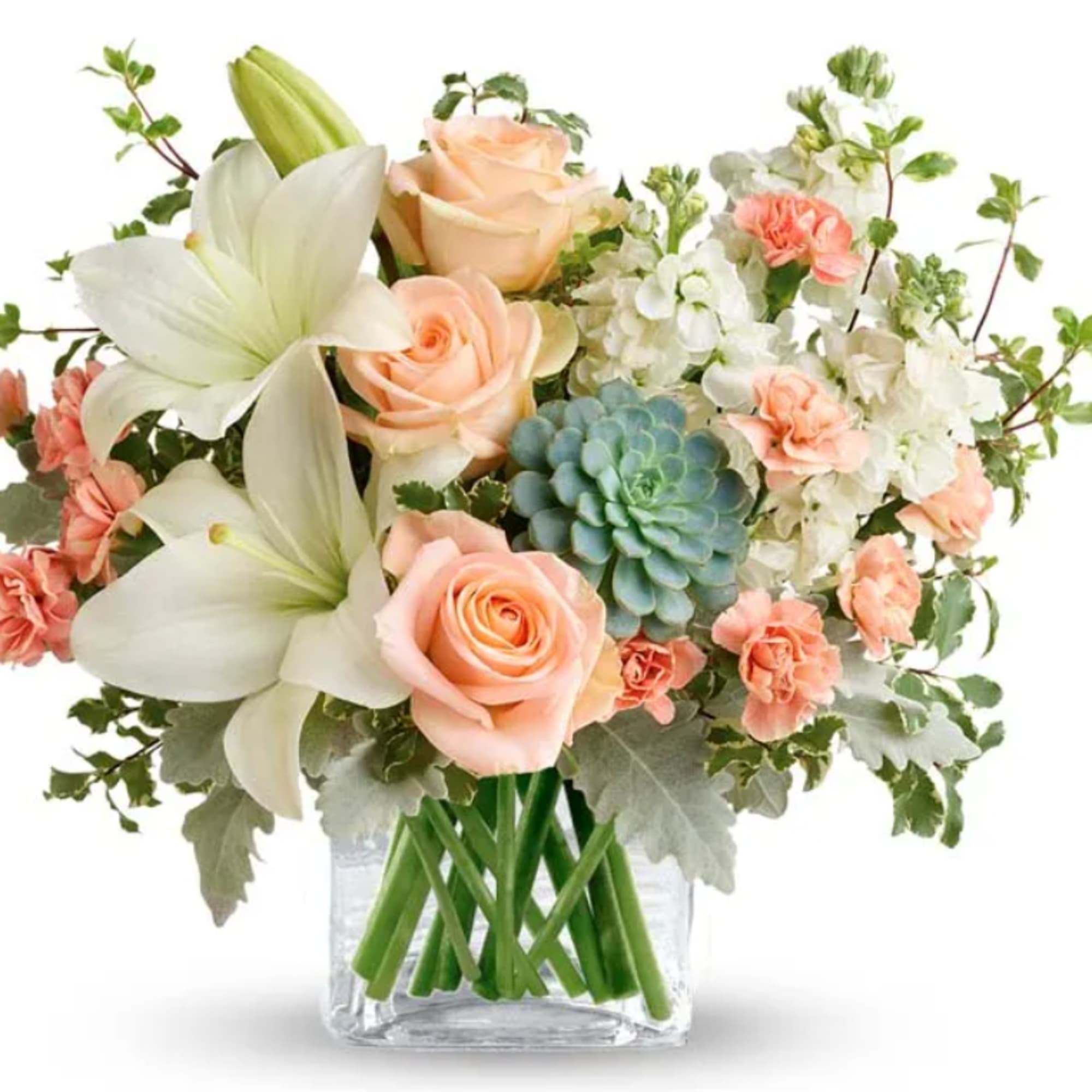 Peach roses and white lilies in a clear glass vase