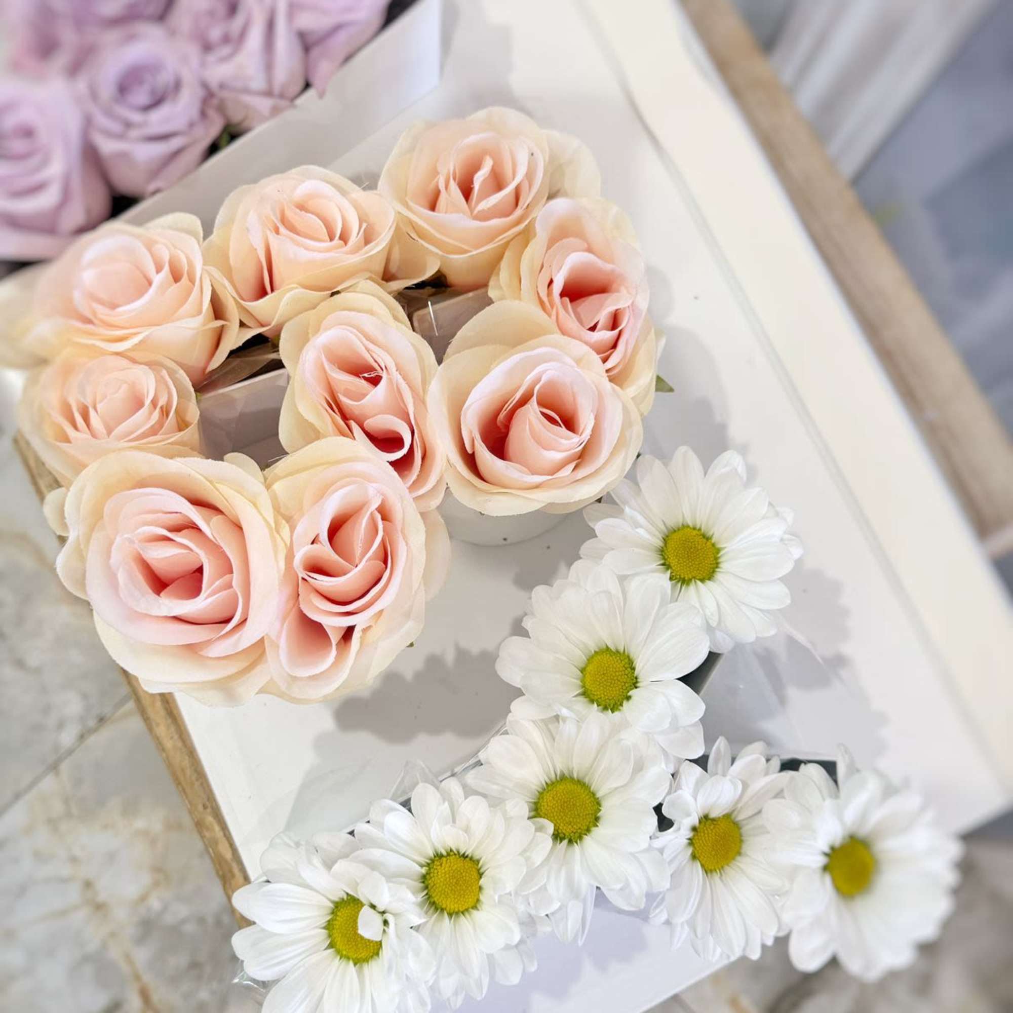 Pastel rose bouquets with white daisies on a white tray