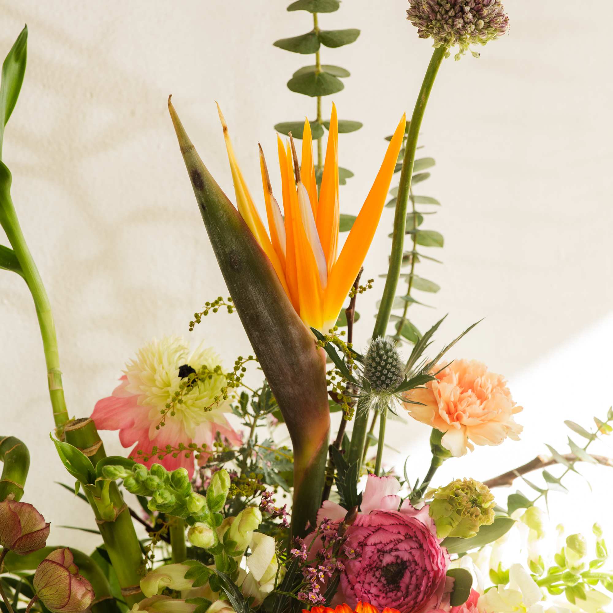 Tall mixed arrangement with orange bird of paradise, gerbera daisy and assorted pastel flowers