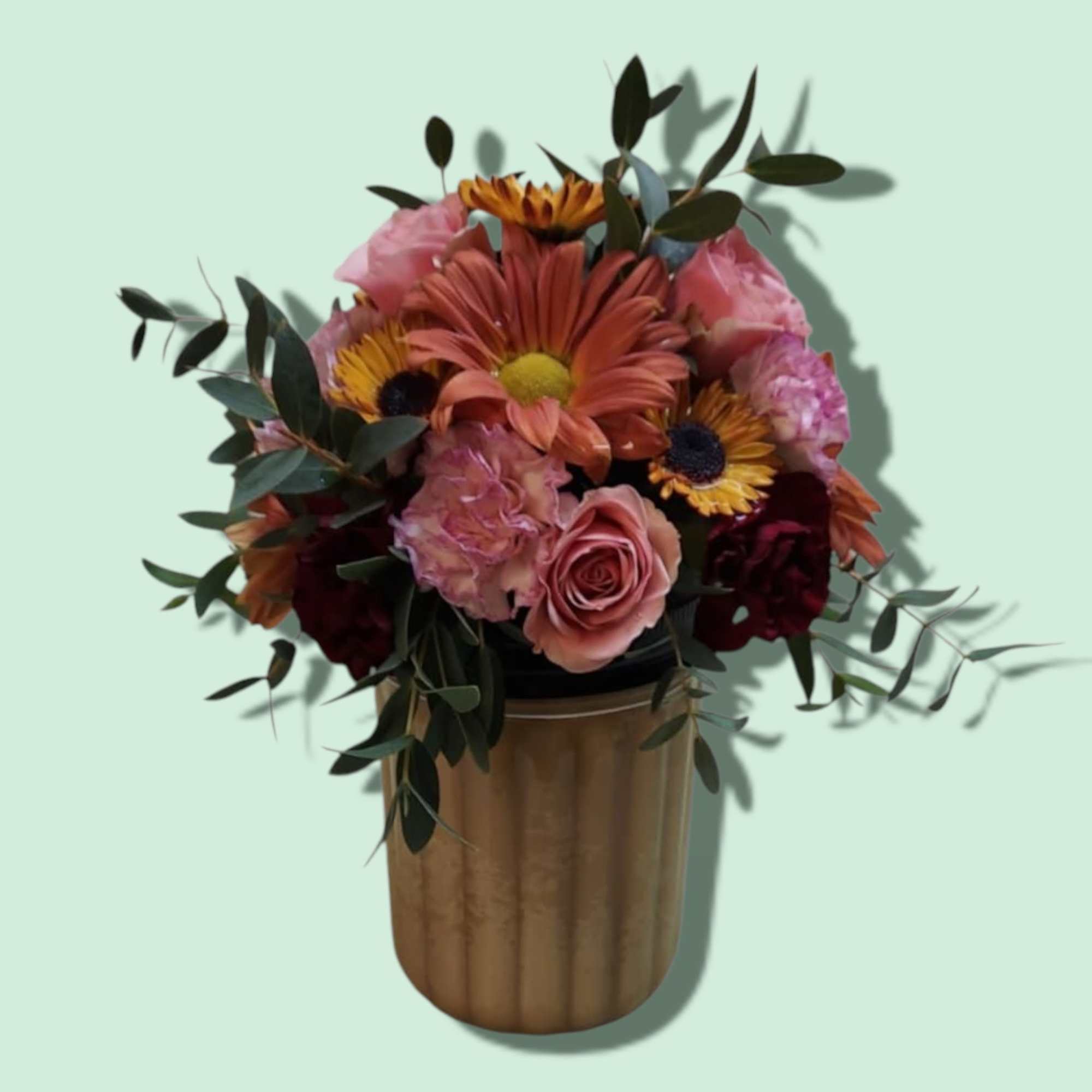 Mixed bouquet in a gold vase with pink and orange flowers