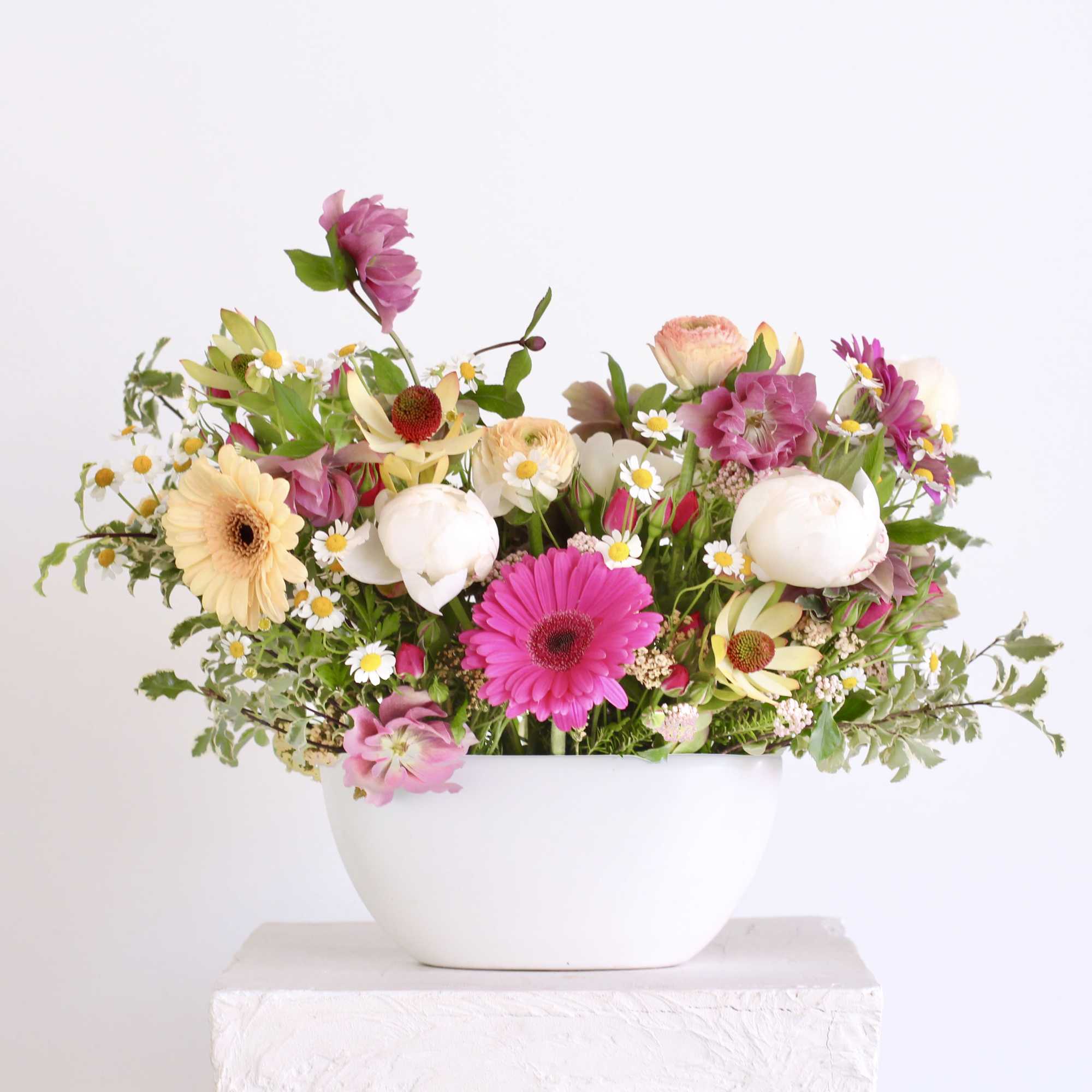 Mixed pink and white flowers in a white bowl vase