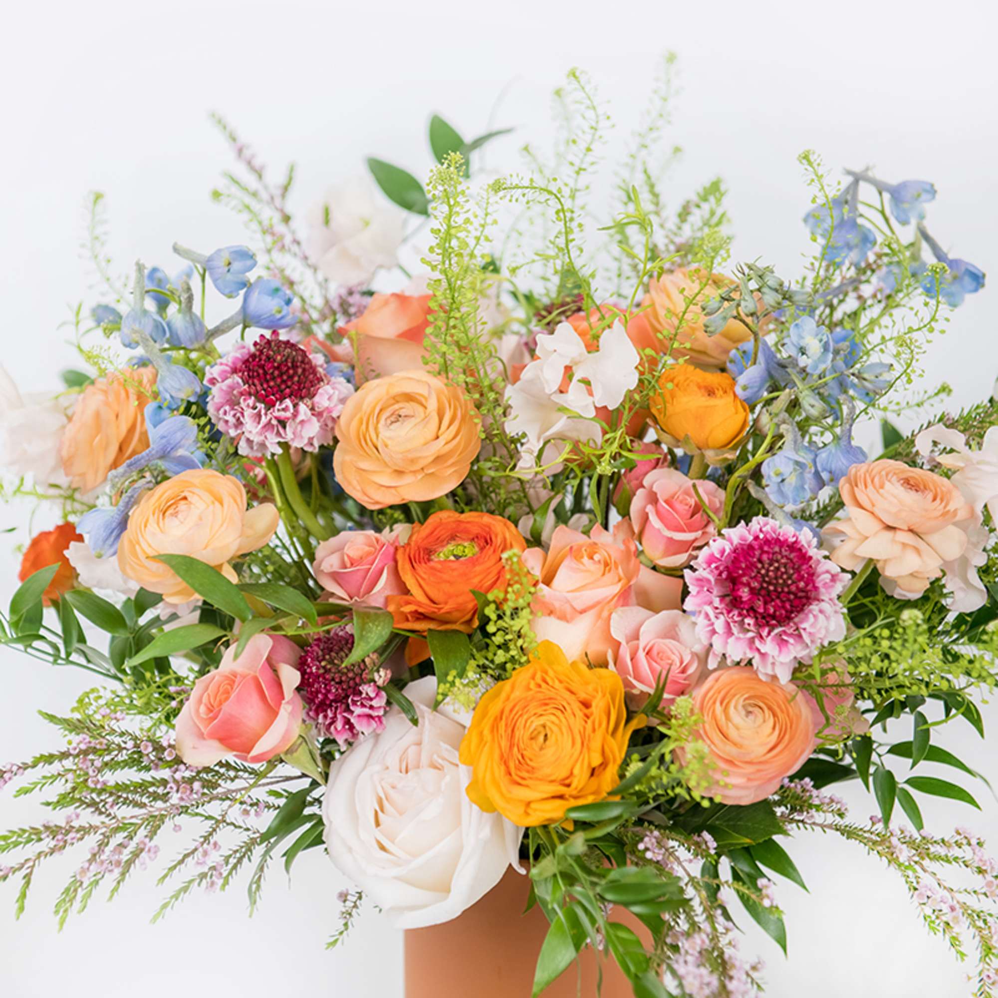Mixed bouquet of peach, pink, white, and blue flowers