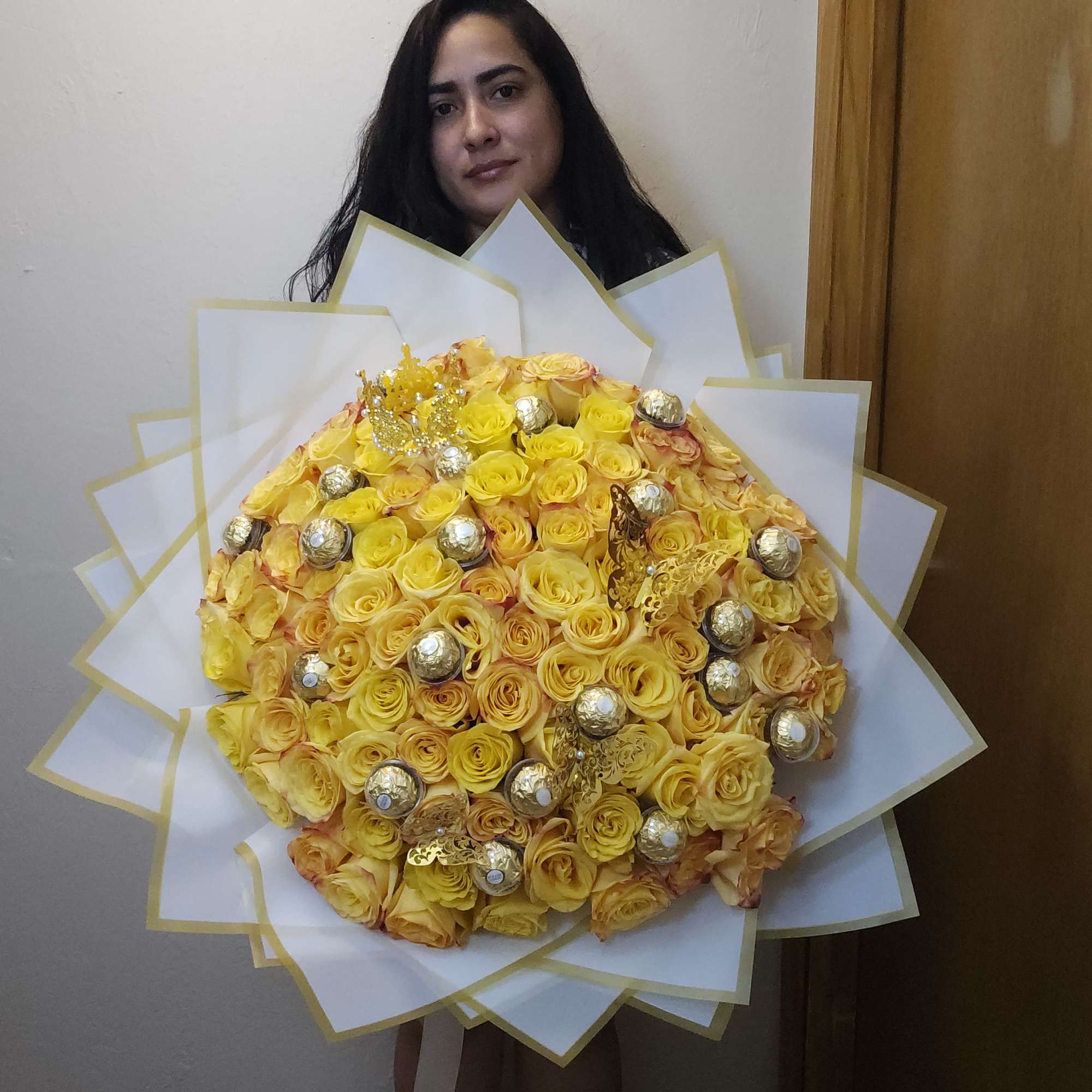 Large bouquet of yellow roses with gold accents and white wrap