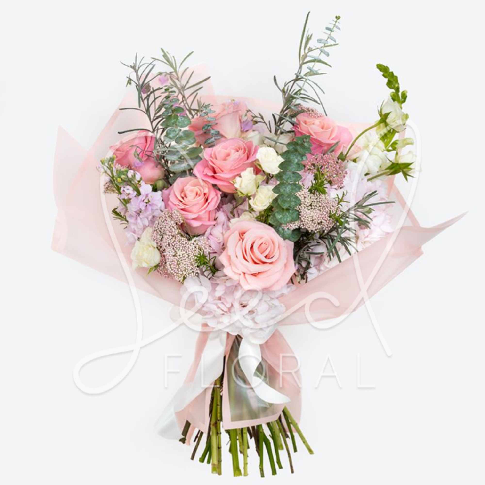 Pink rose bouquet with white accent flowers and pale wrapping
