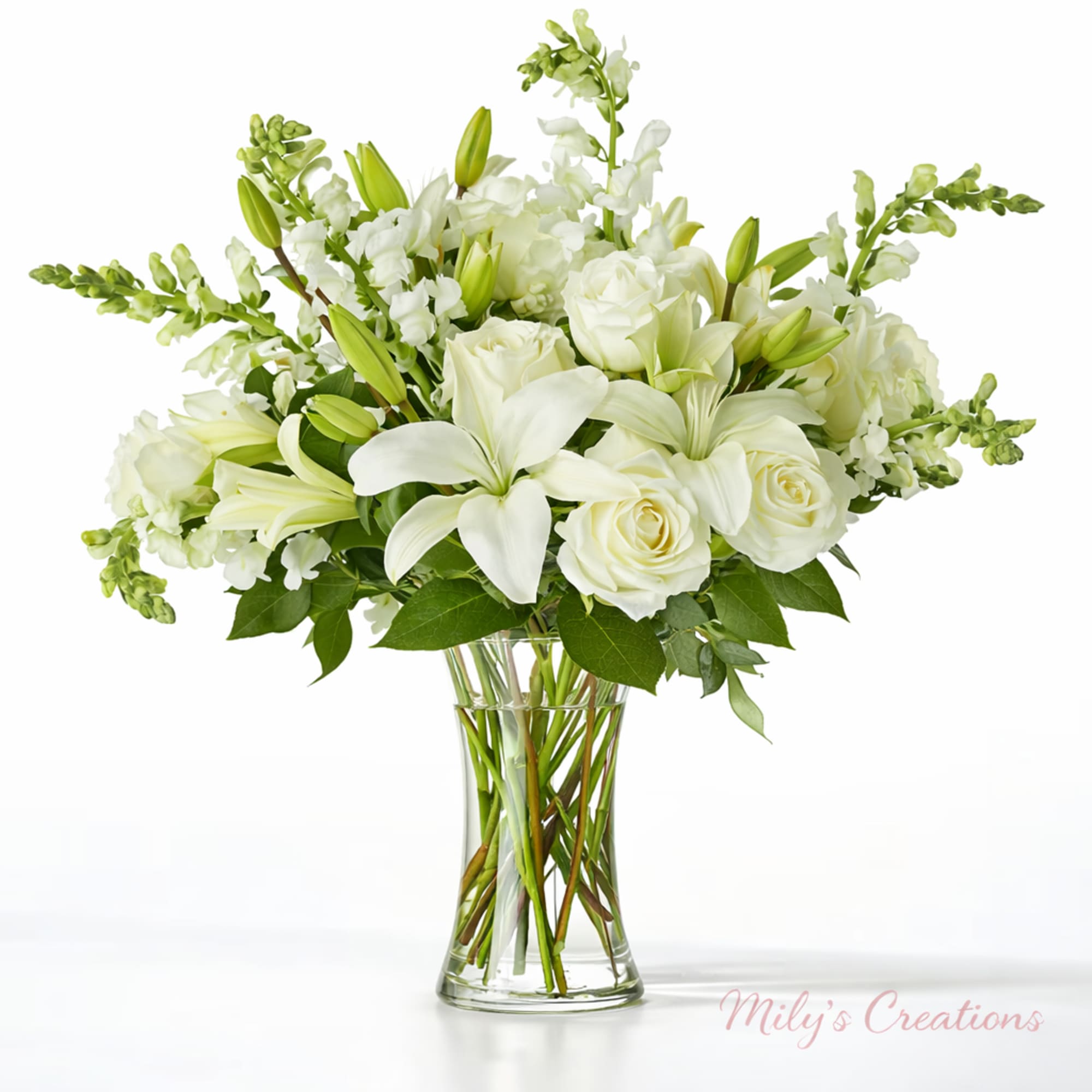 White lilies, roses, and snapdragons arranged in a clear glass vase