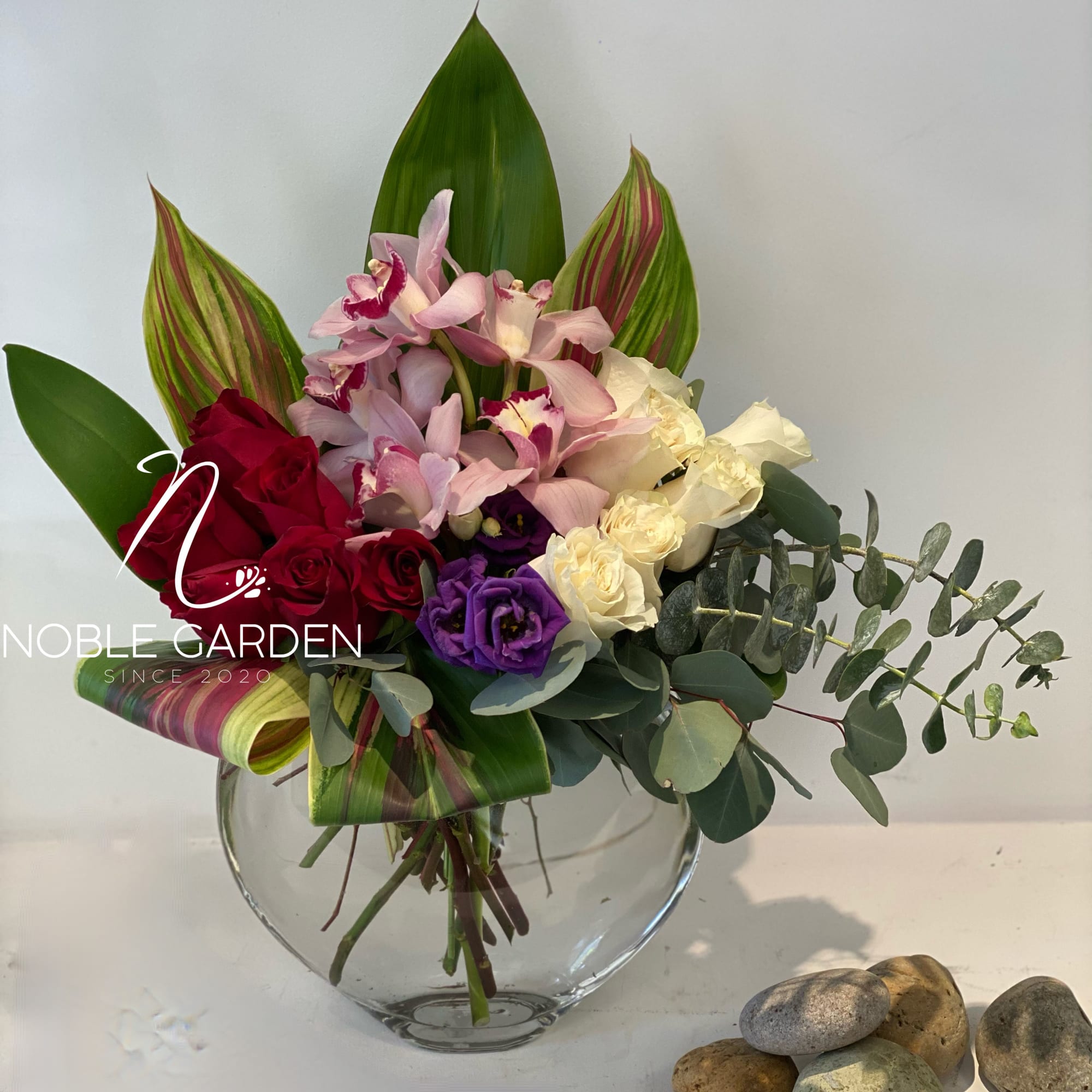 Mixed bouquet of roses and orchids in a glass vase