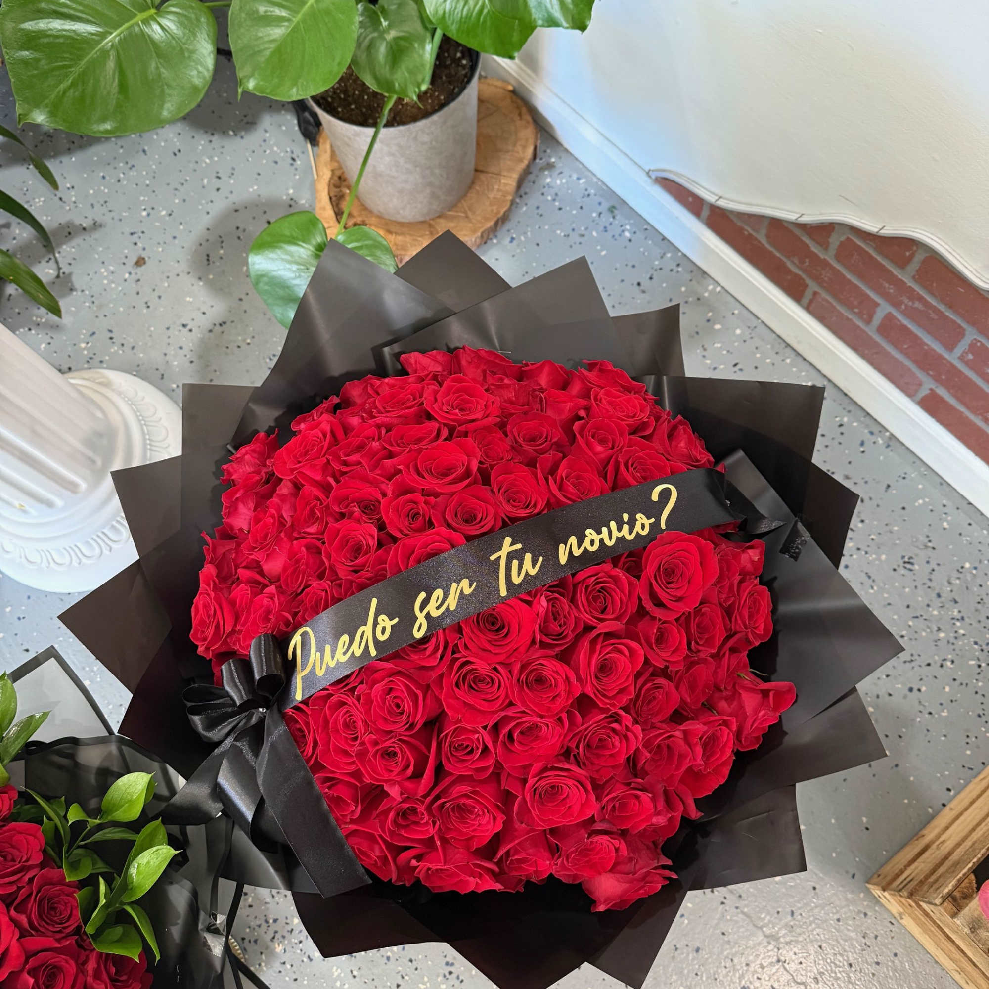 Large bouquet of red roses wrapped in black paper with a ribbon