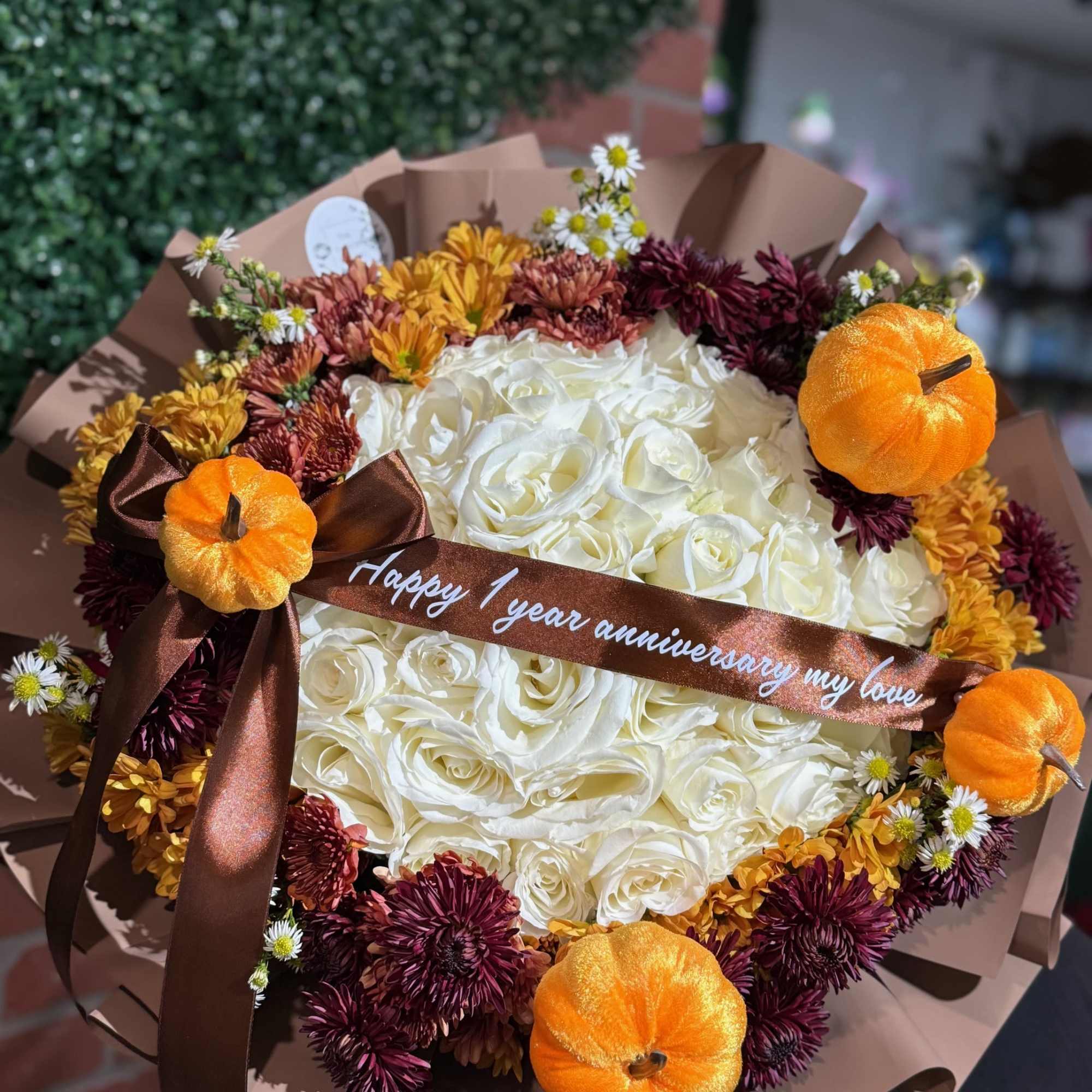 Bouquet of white roses with autumn mums and small pumpkins