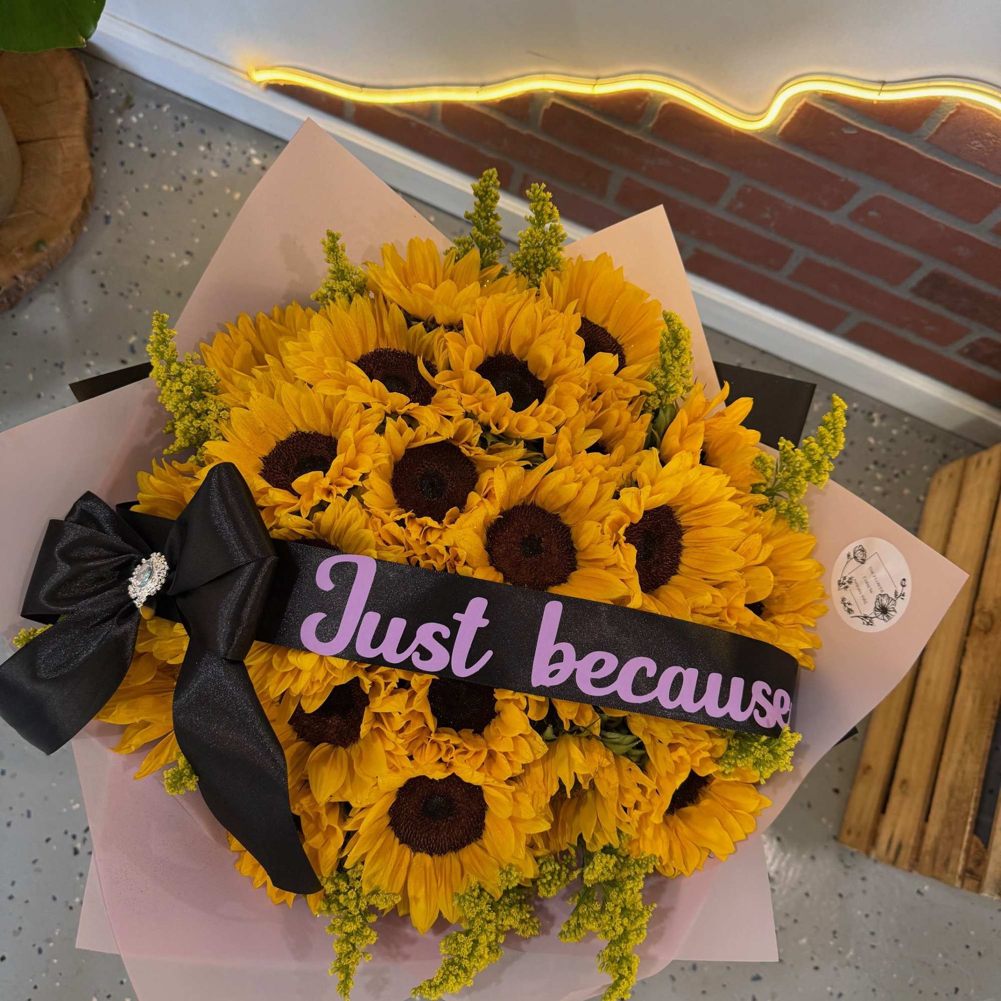 Bouquet of yellow sunflowers wrapped with pink paper and a black ribbon